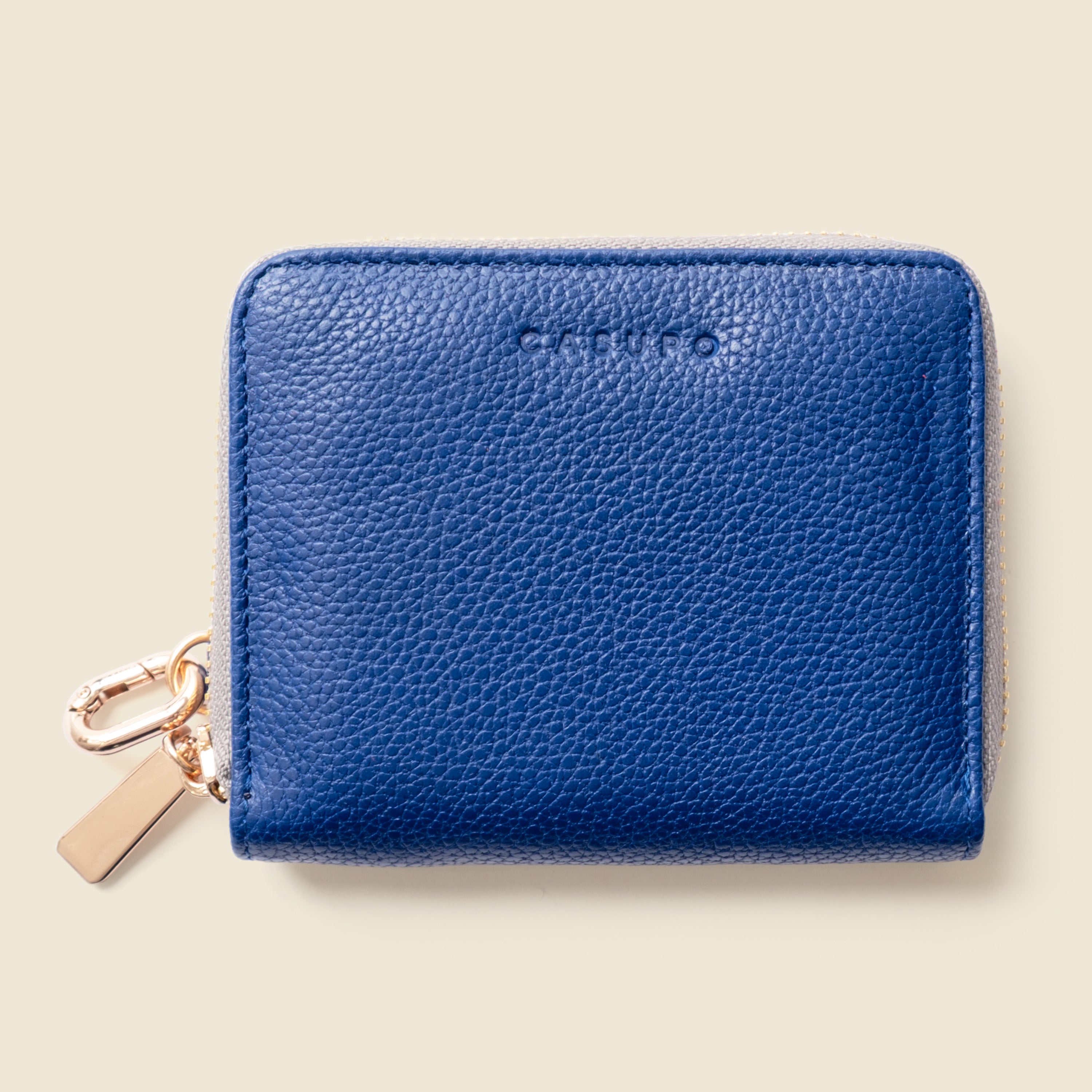 Blue wallet with a gold tag on a beige background