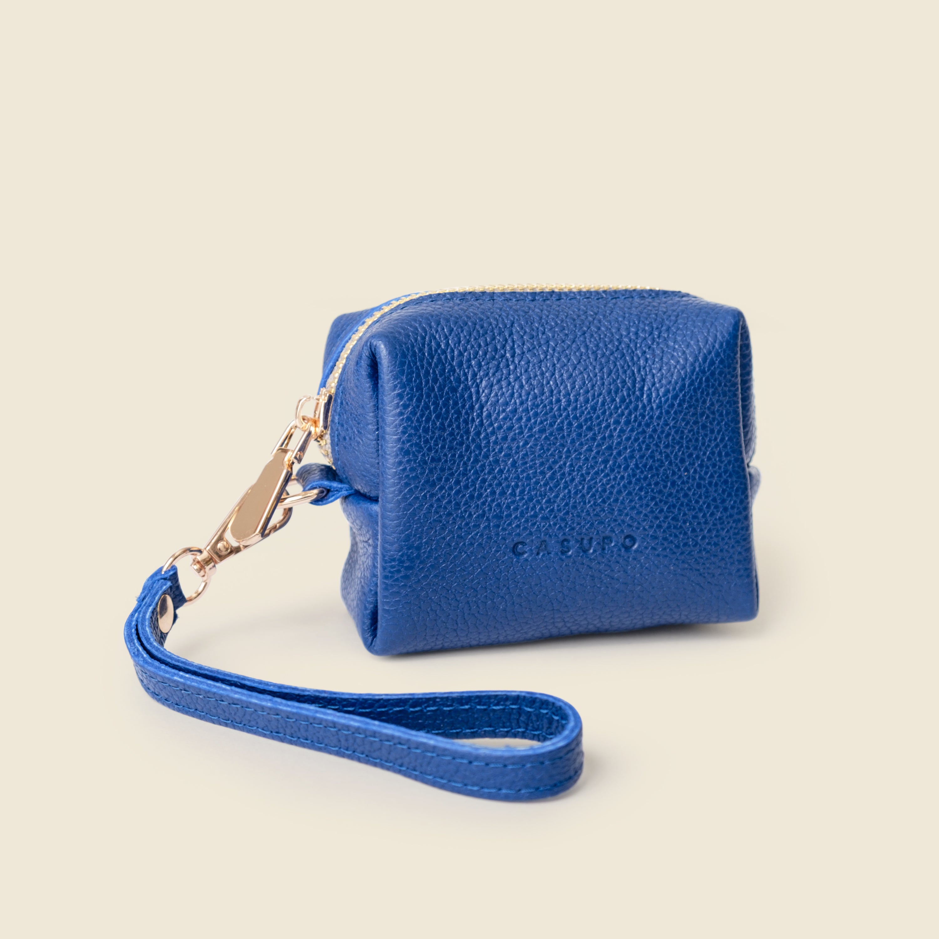 Blue leather pouch with a strap on a beige background