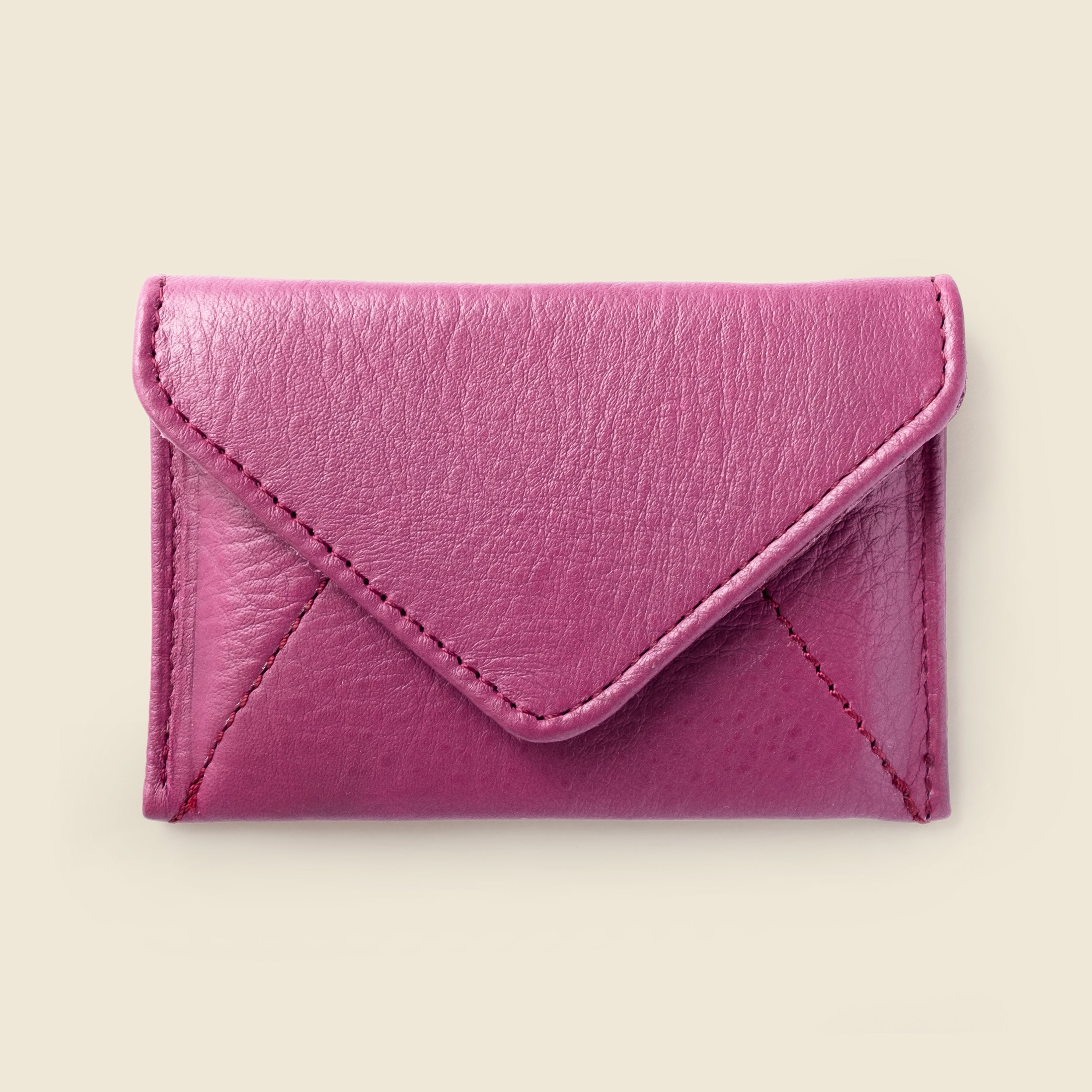 Pink leather cardholder on a beige background