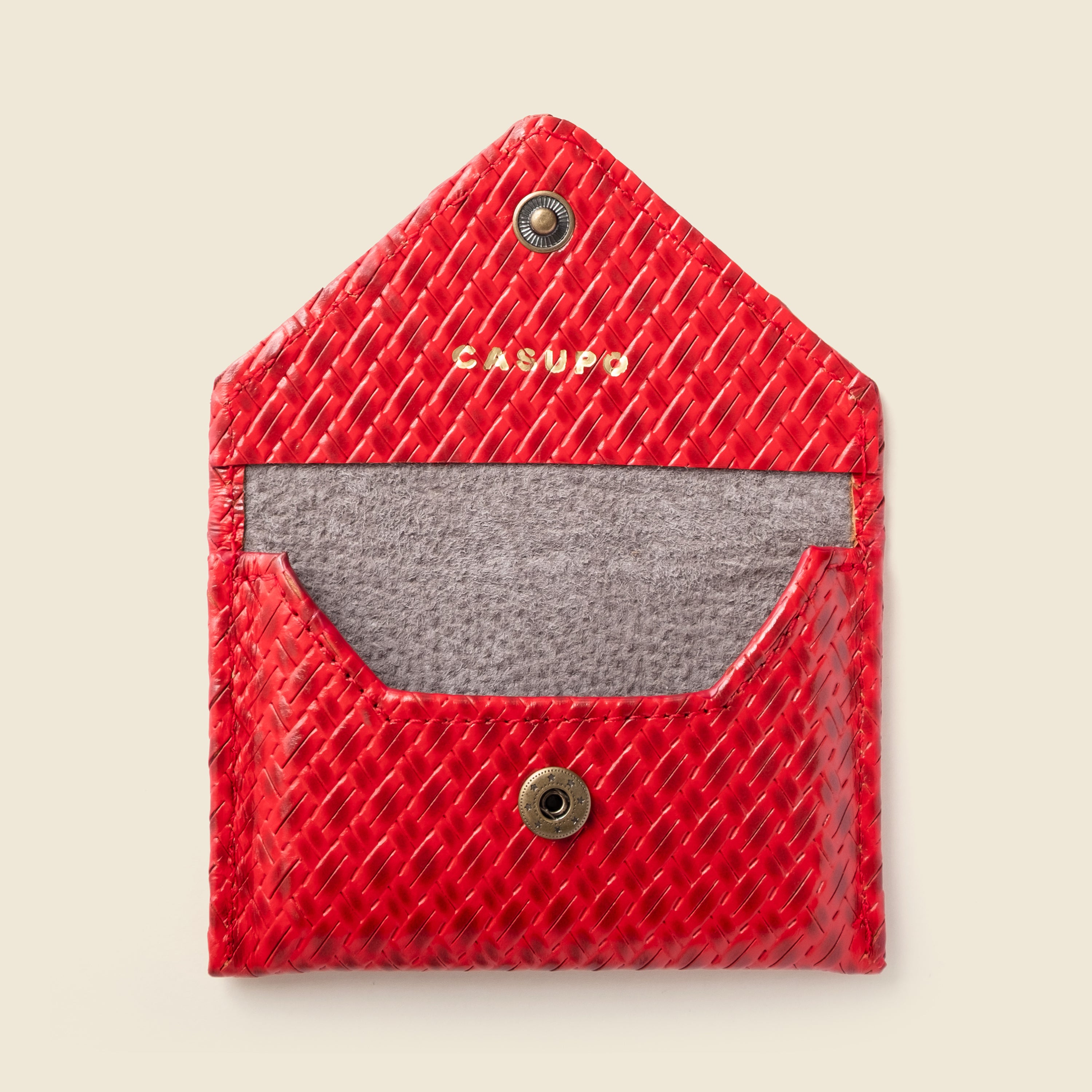 Red textured pouch with a gray interior and 'Casupo' branding on a beige background