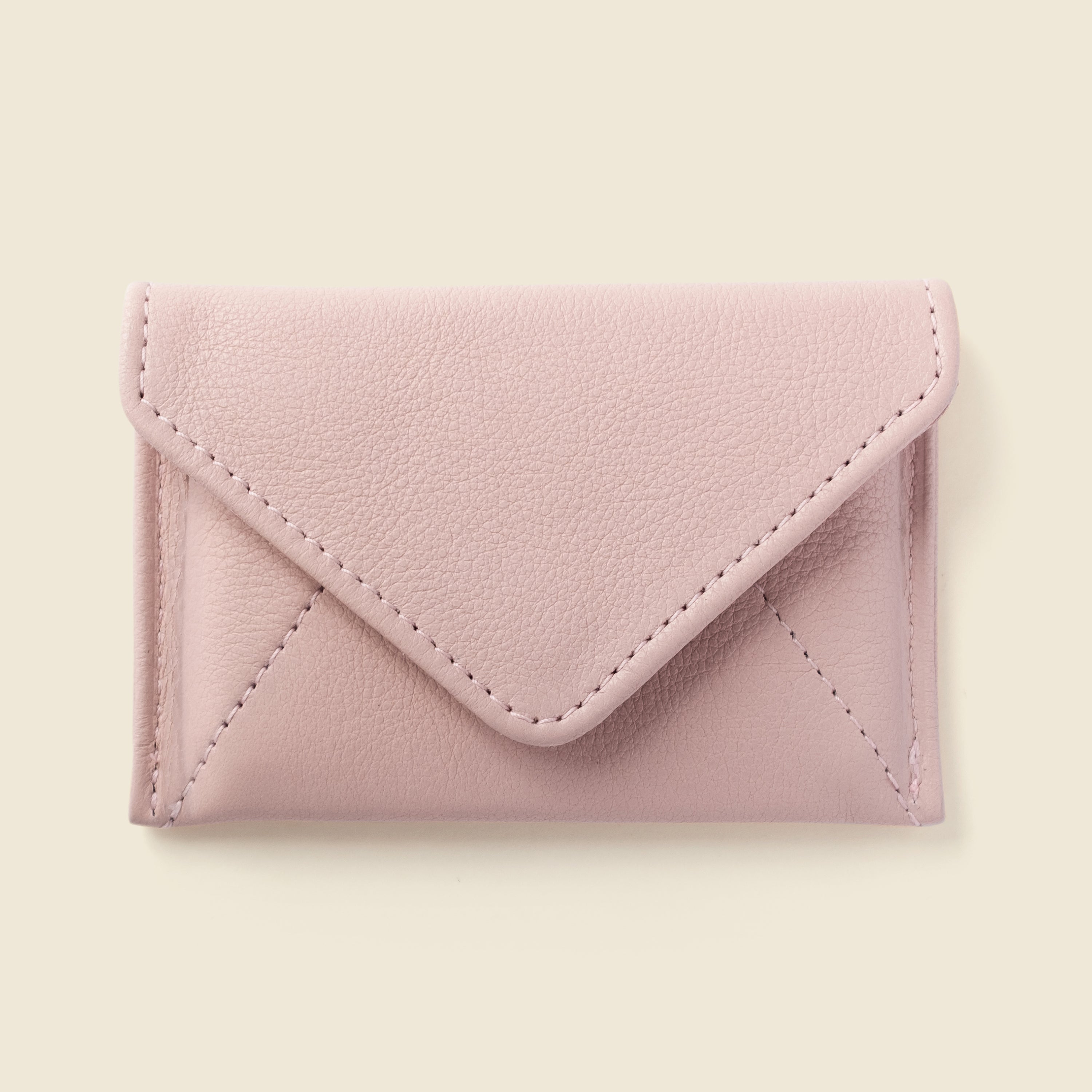 Pink leather cardholder on a beige background