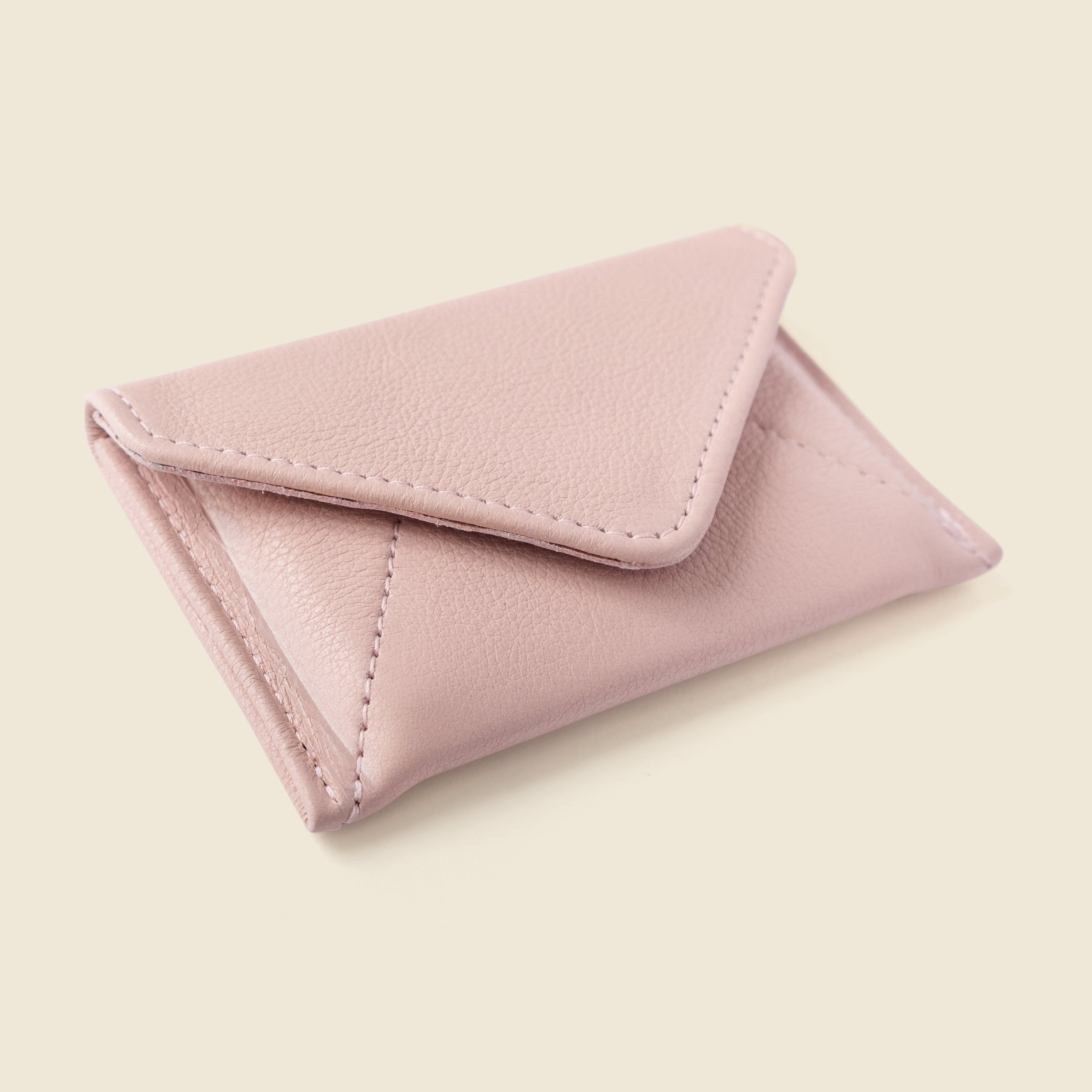 Pink leather cardholder on a beige background