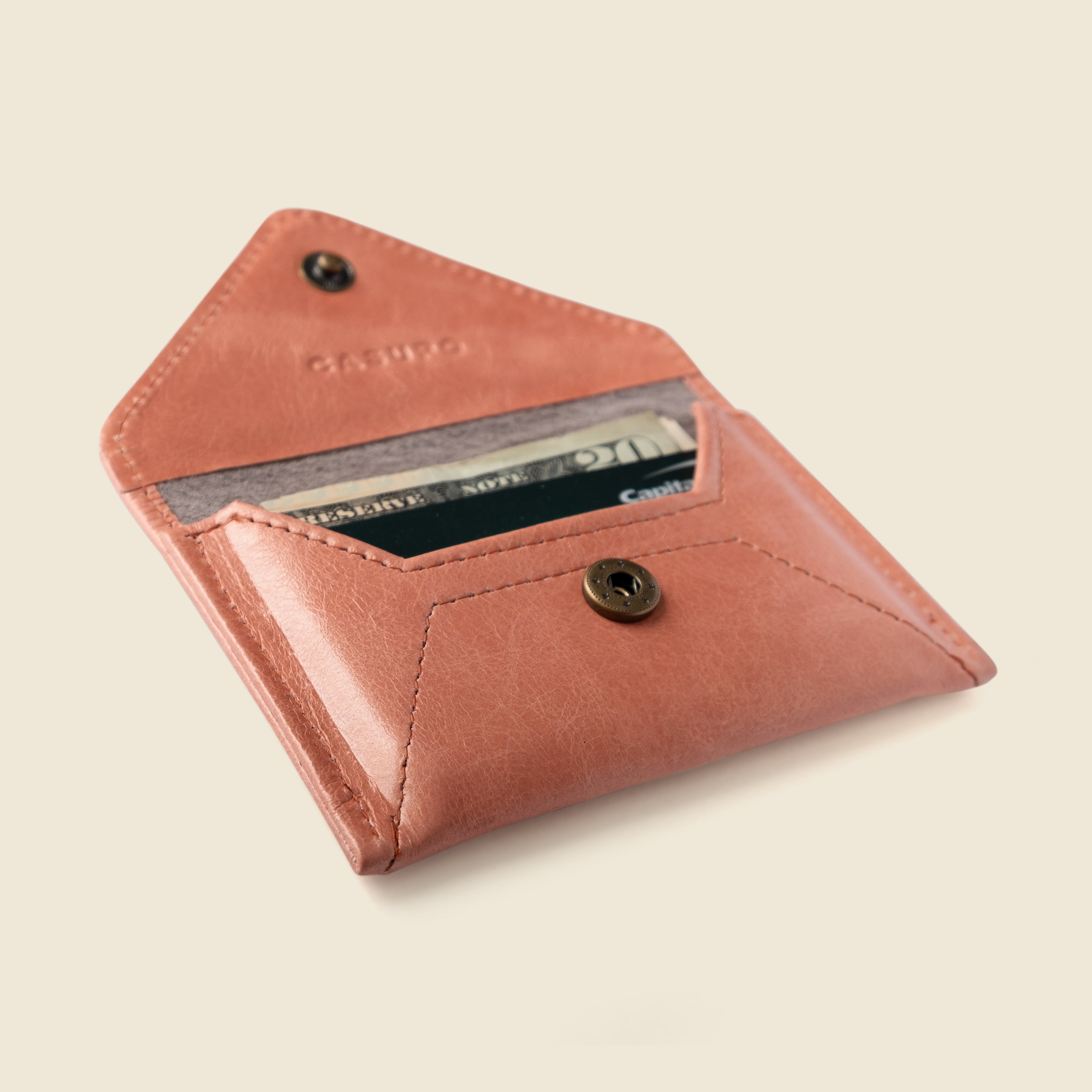 Pink leather wallet with a card holder on a beige background
