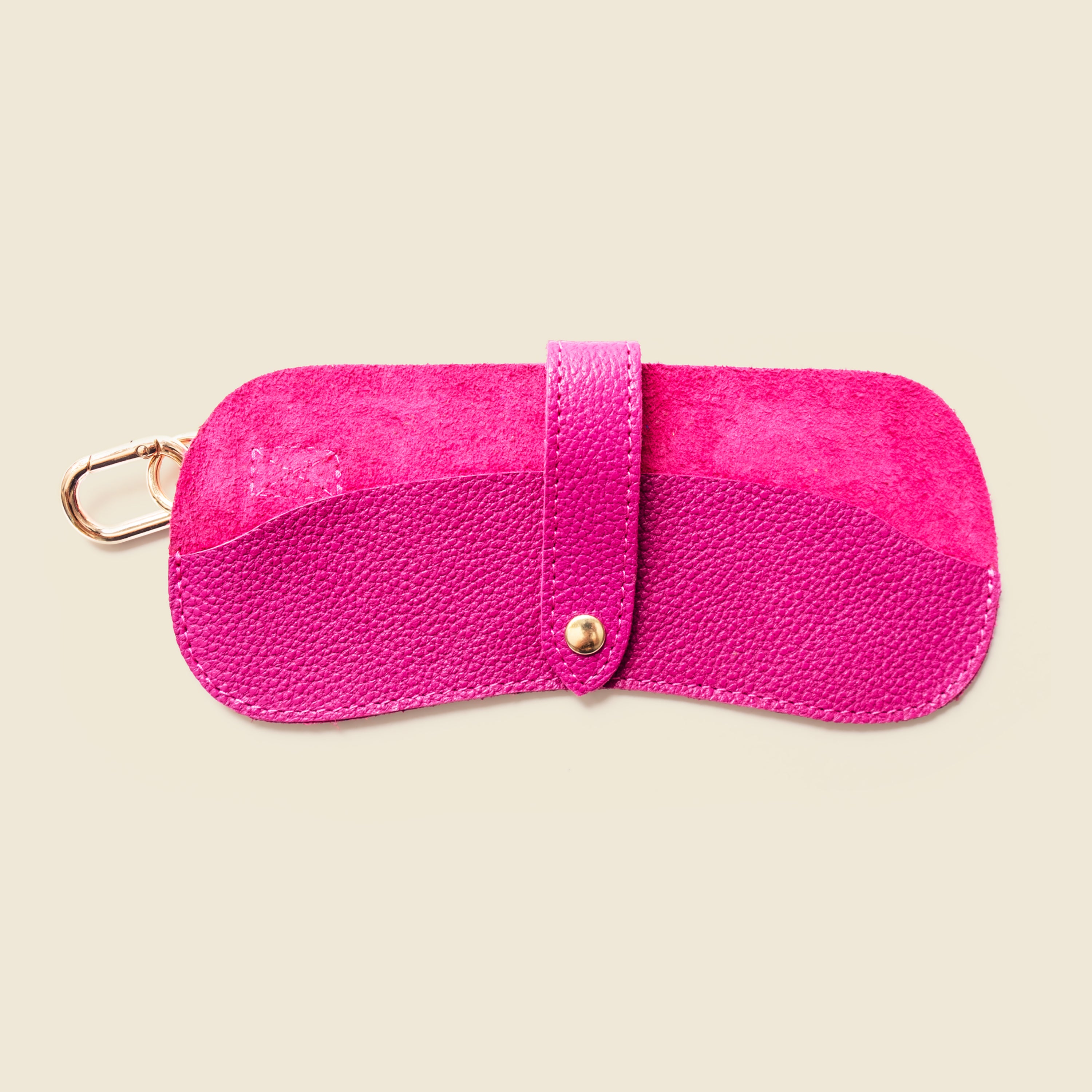 Pink leather keychain case on a beige background
