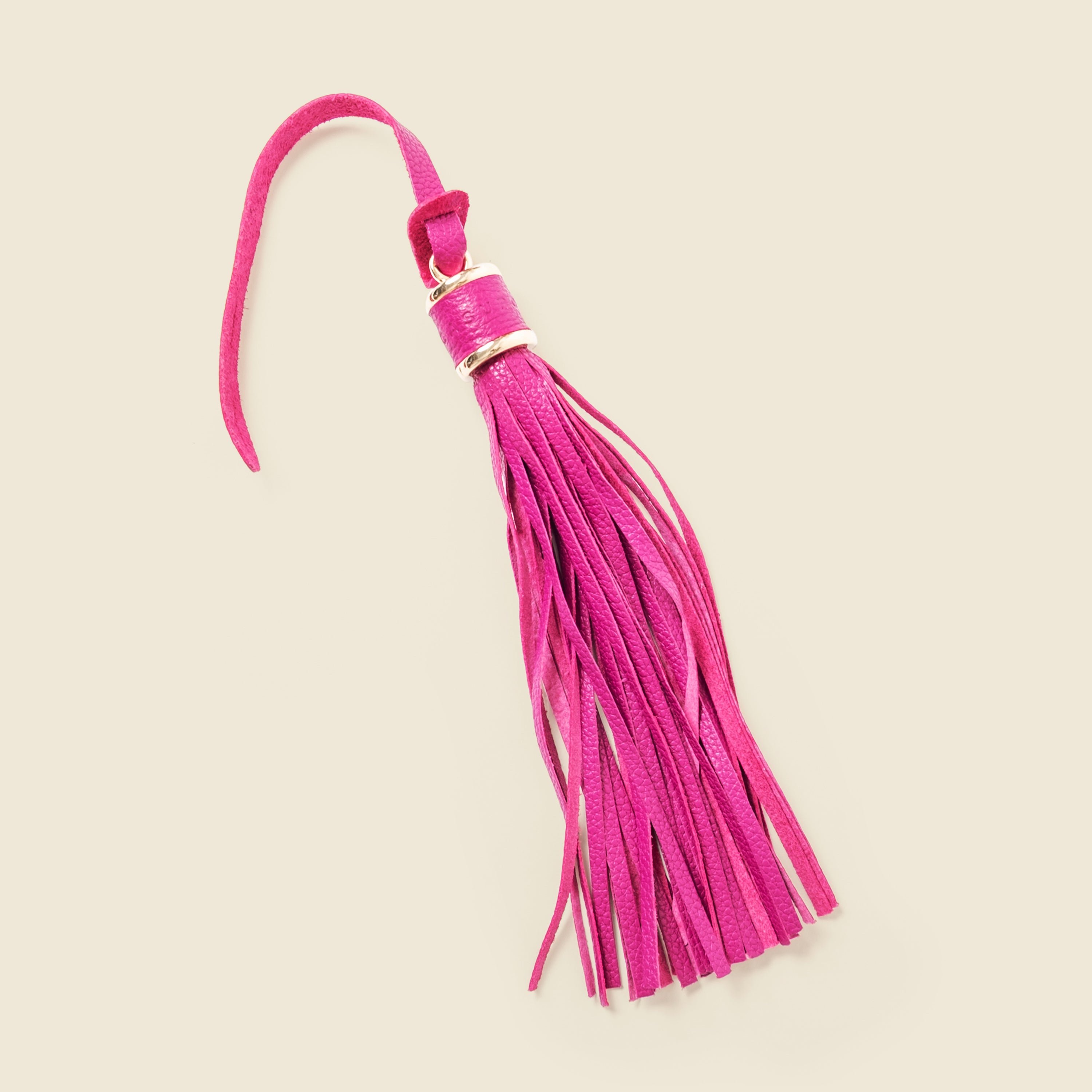 Pink leather tassel on a beige background