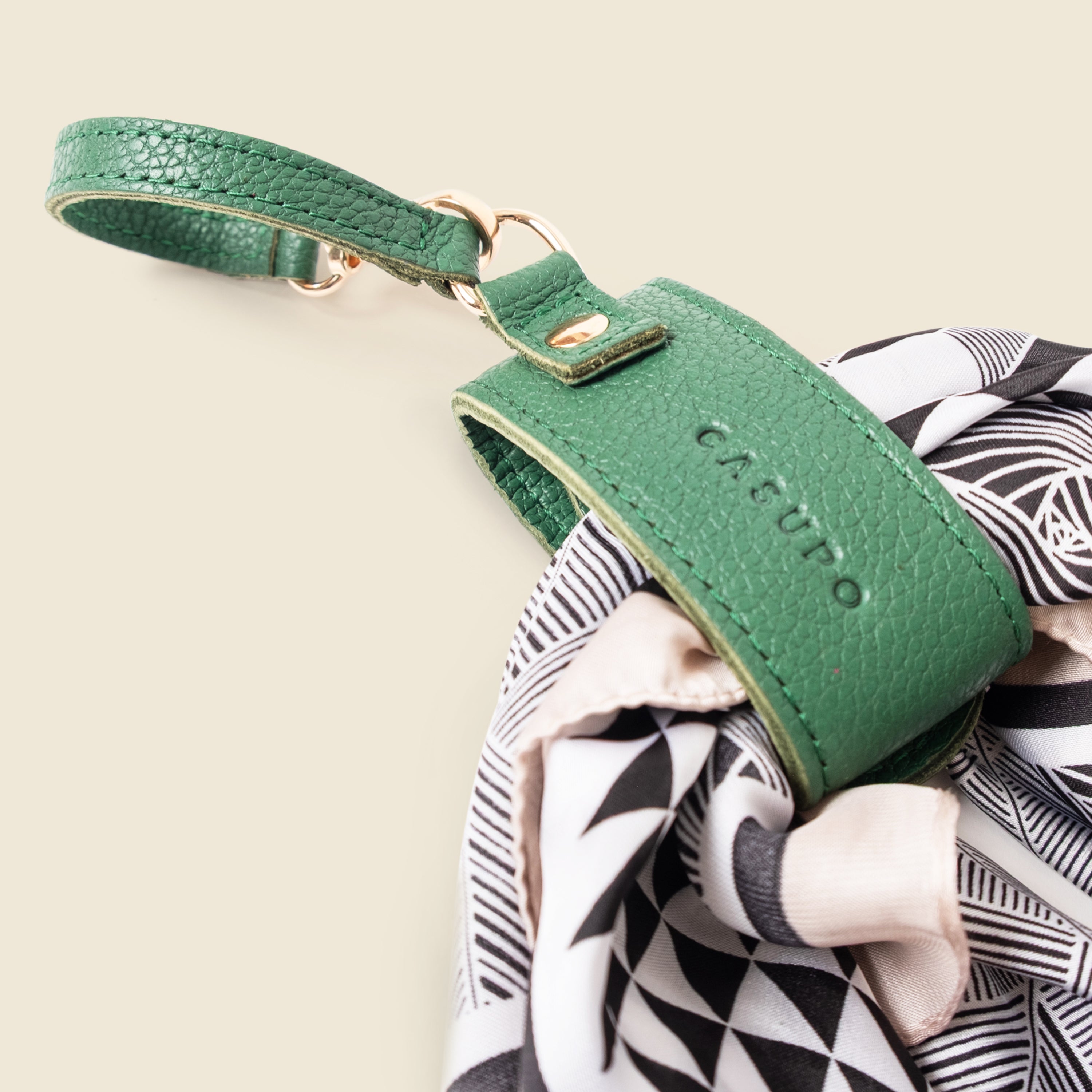 Green leather strap with CASUPO branding on a patterned fabric background