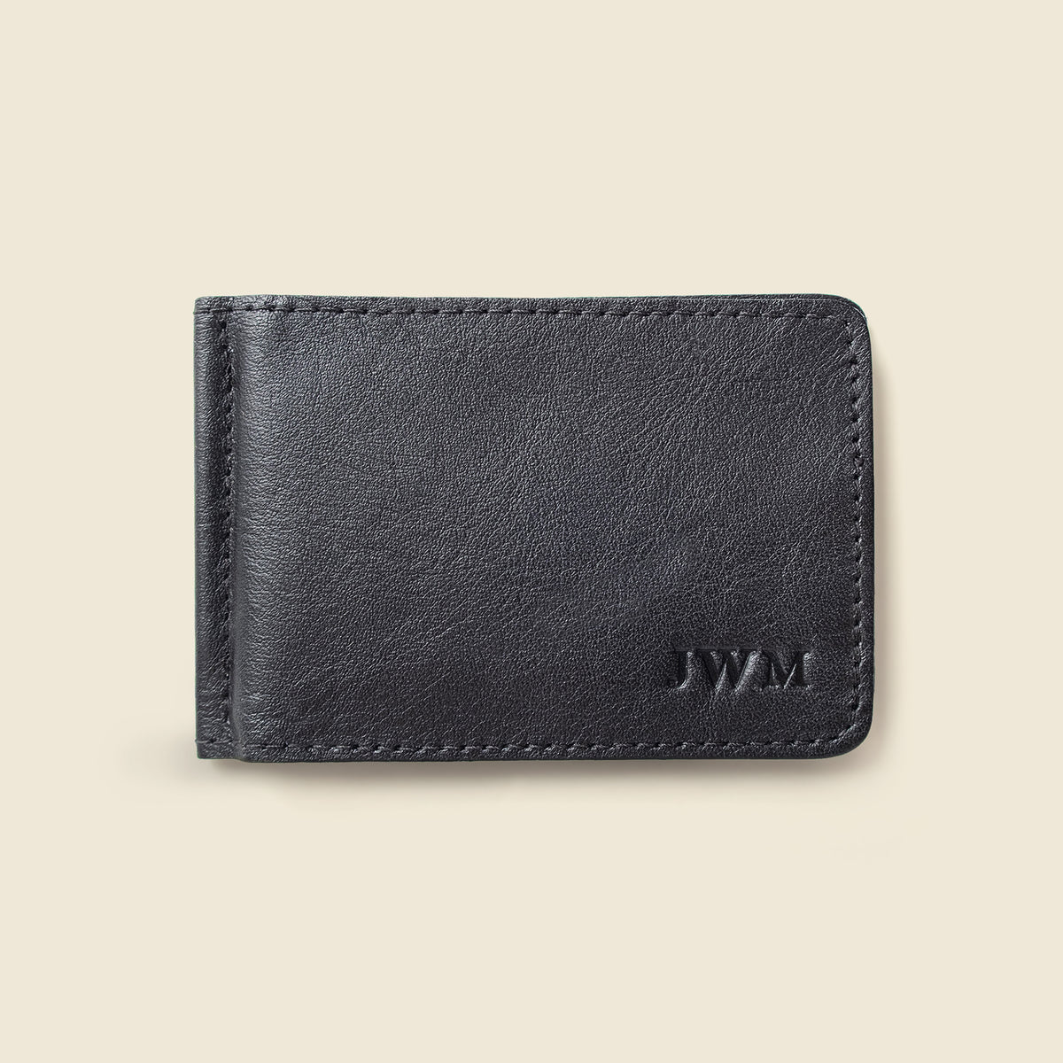 A dark navy blue leather bifold wallet with a debossed 'JWM' logo in the bottom right corner, shown on a light beige background.