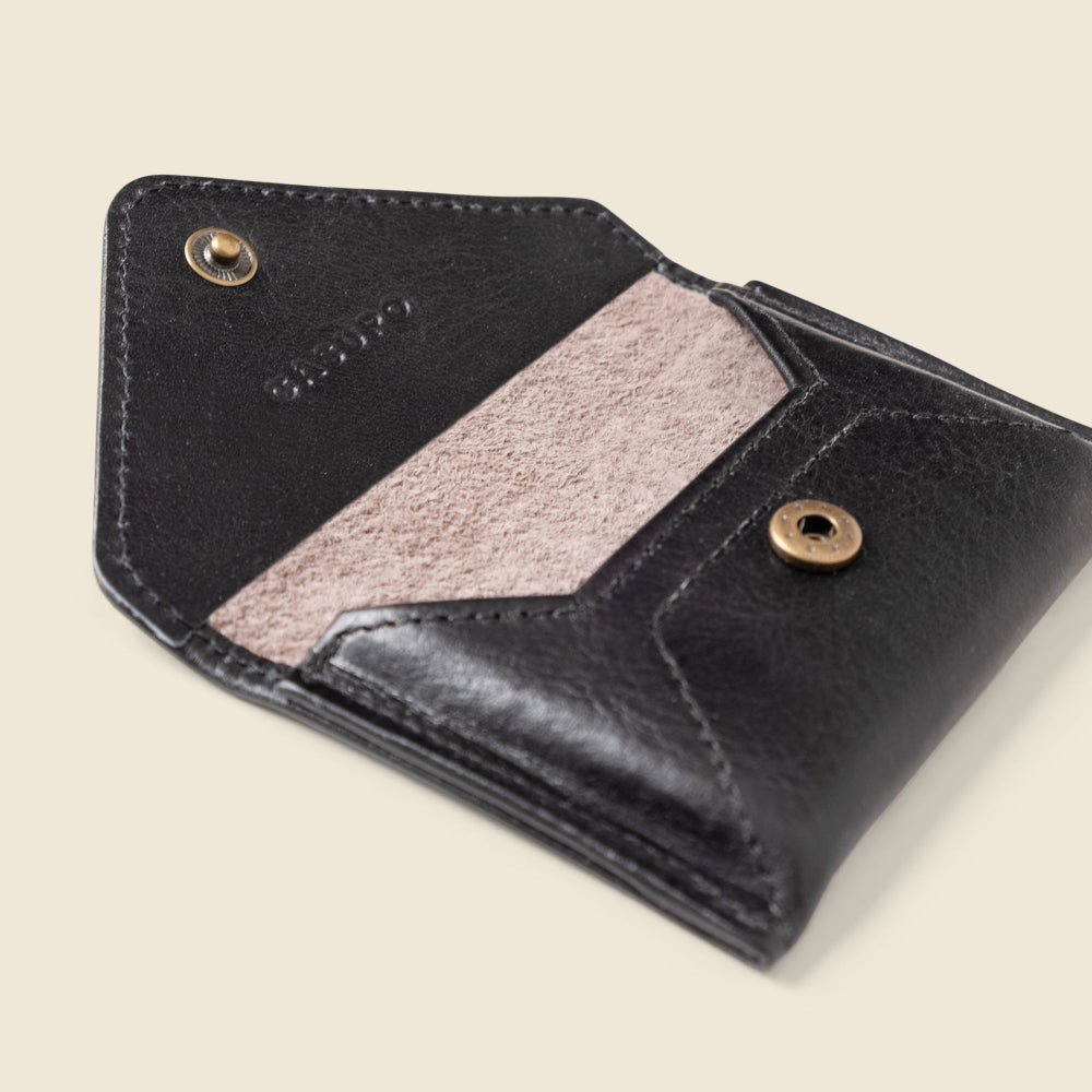 Black leather wallet with pink interior on a beige background