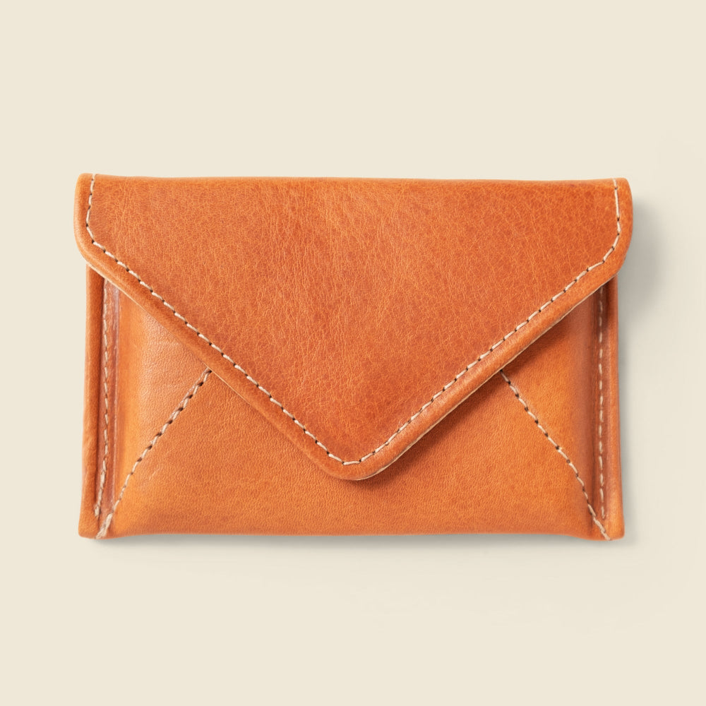 Brown leather cardholder on a beige background