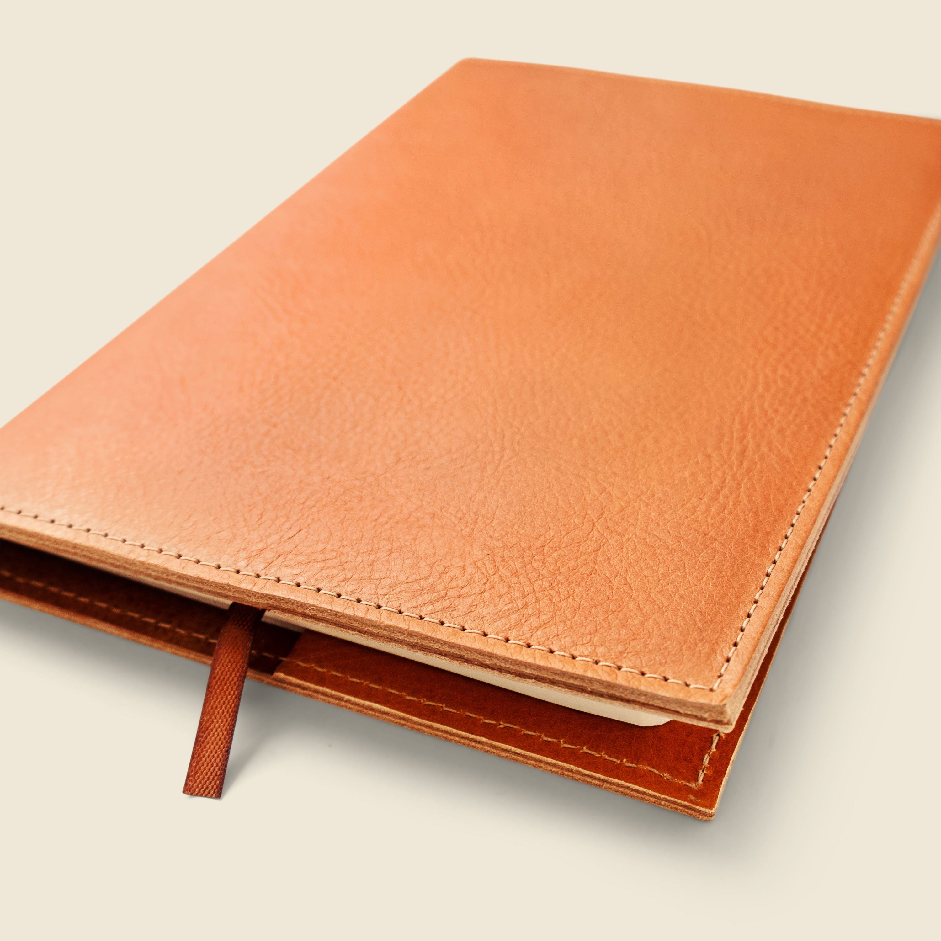 Brown leather notebook on a light beige background