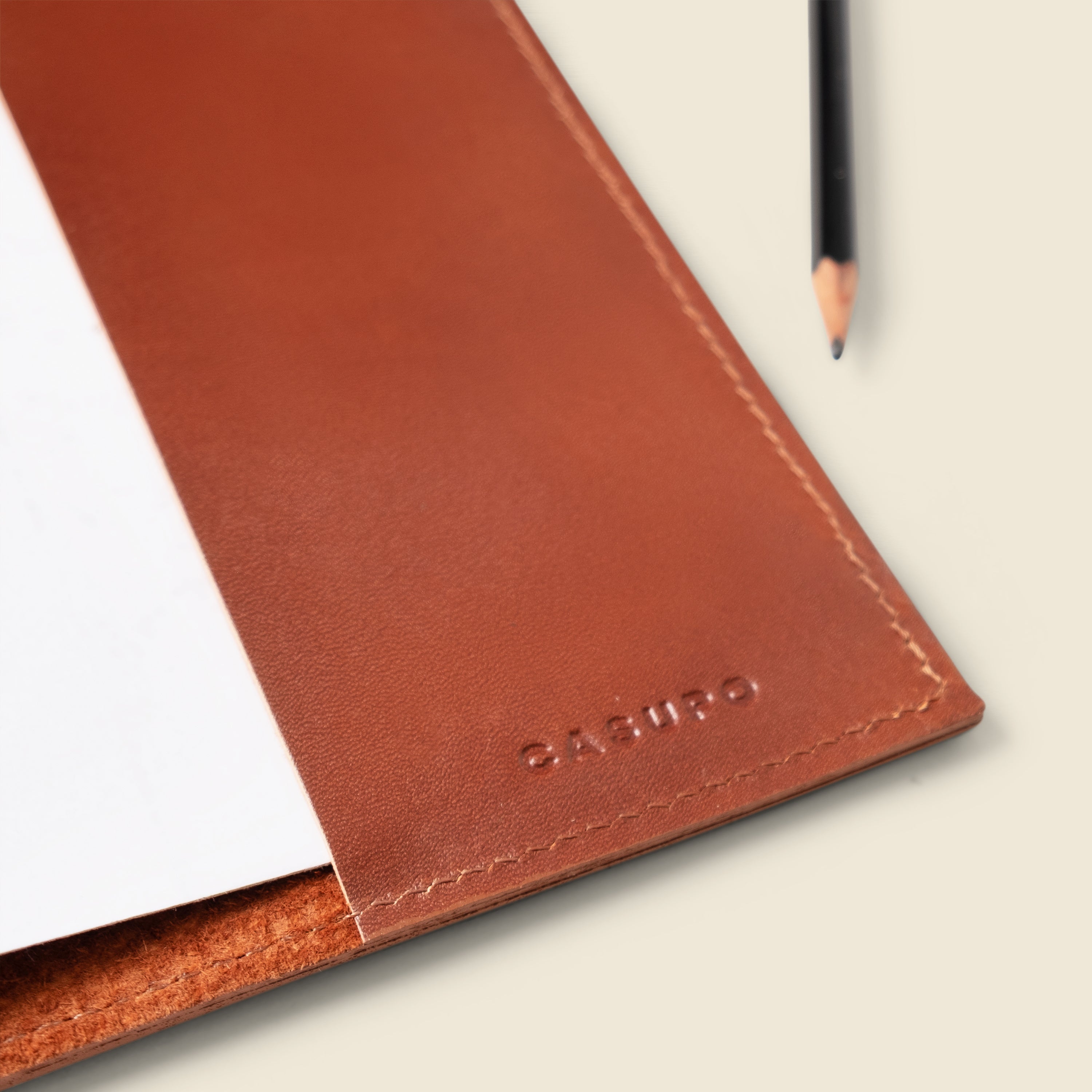 Brown leather notebook with 'Casual' branding on a light background