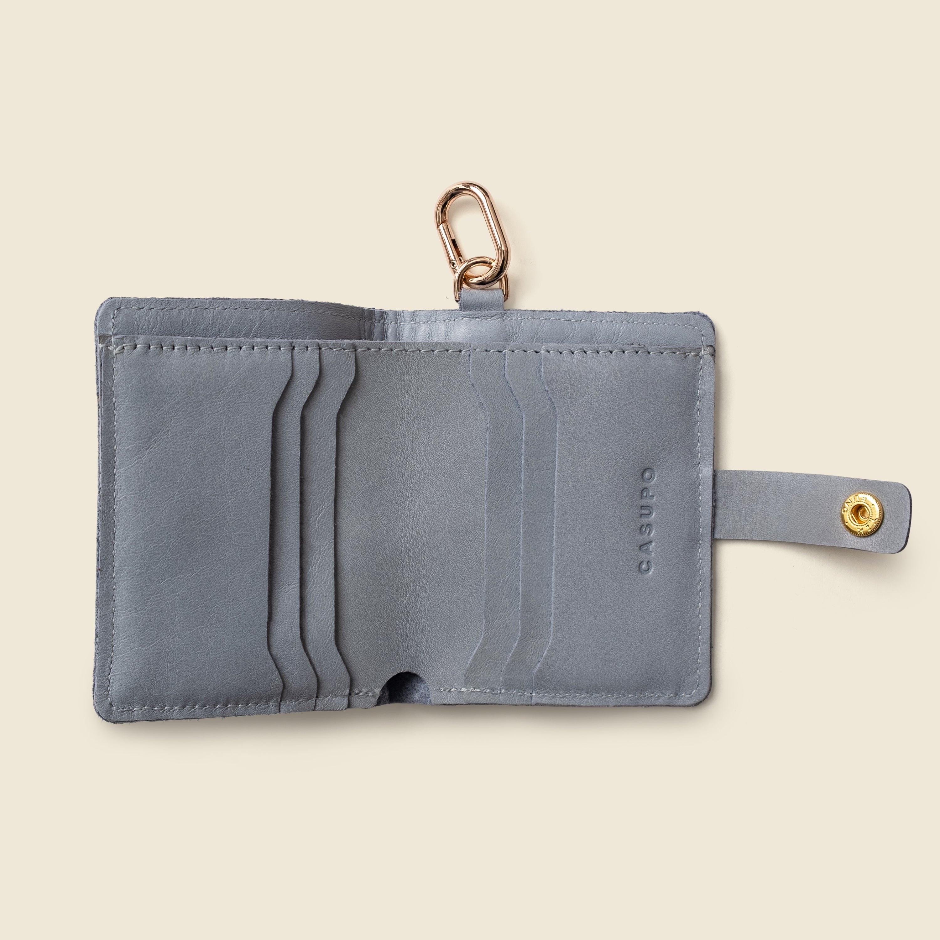 Close-up of snap closure on ice blue leather wallet with key ring