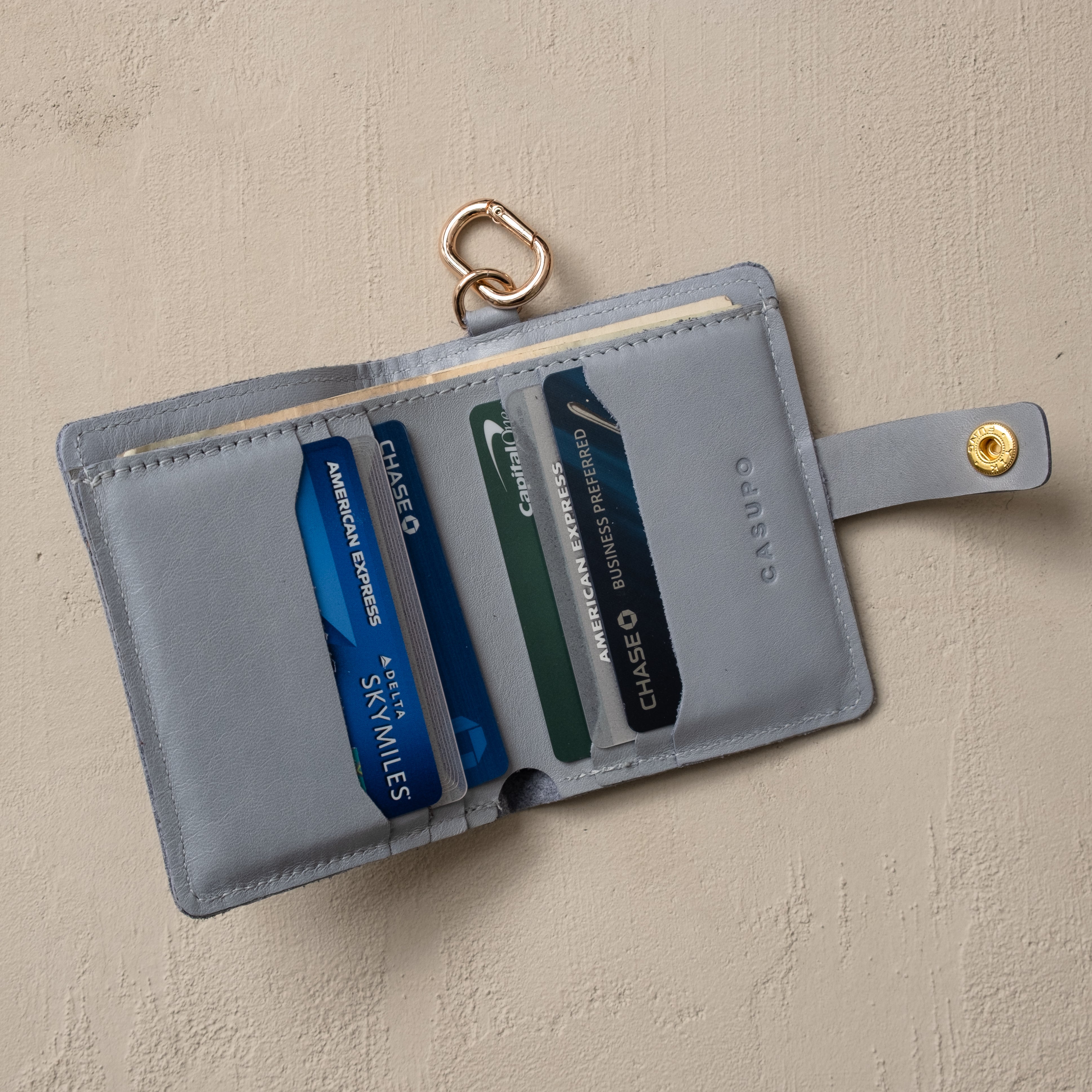 Ice blue snap wallet with key ring, lifestyle flat lay