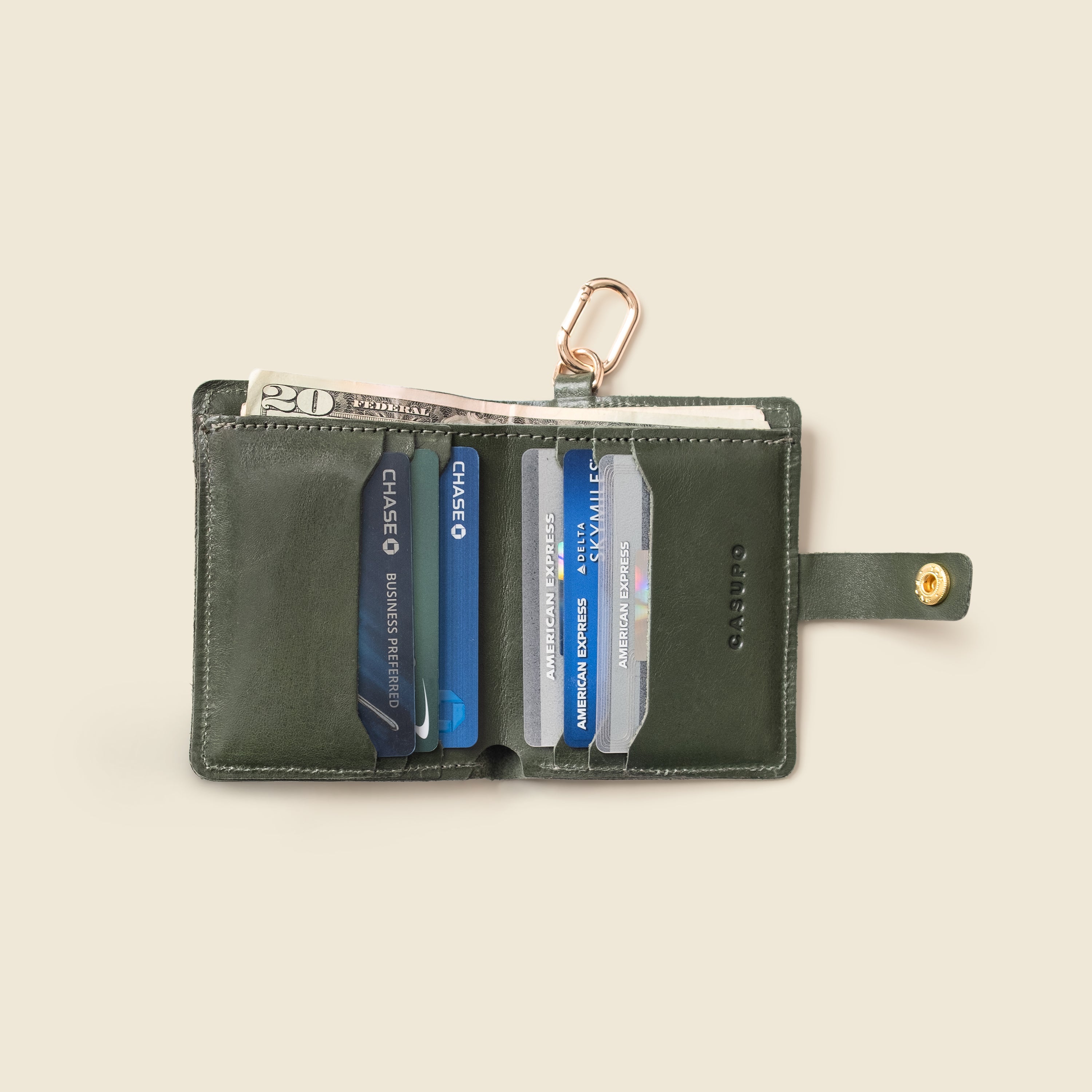 Close-up of snap closure on olive leather wallet with key ring