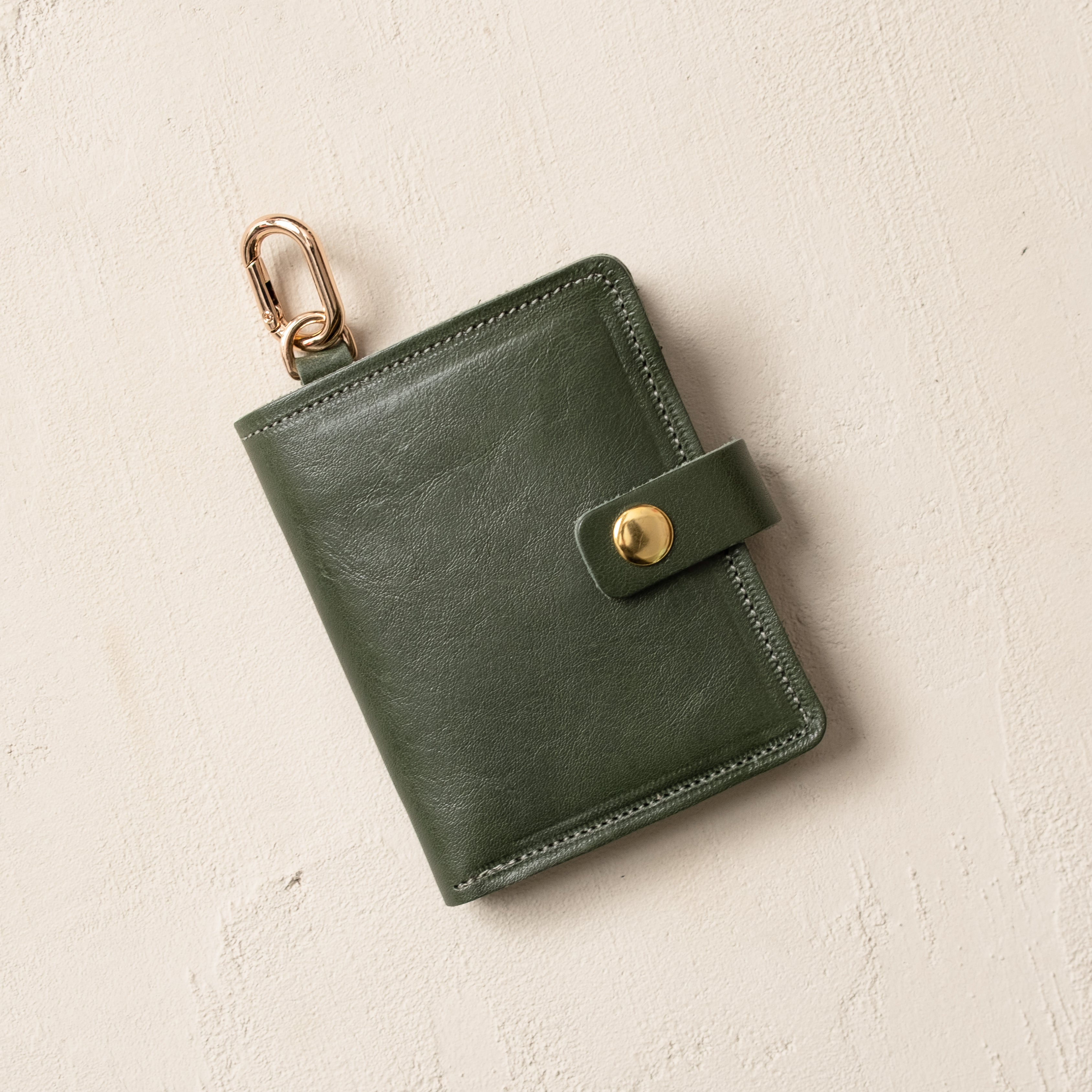 Olive leather wallet with key ring, front view on neutral background