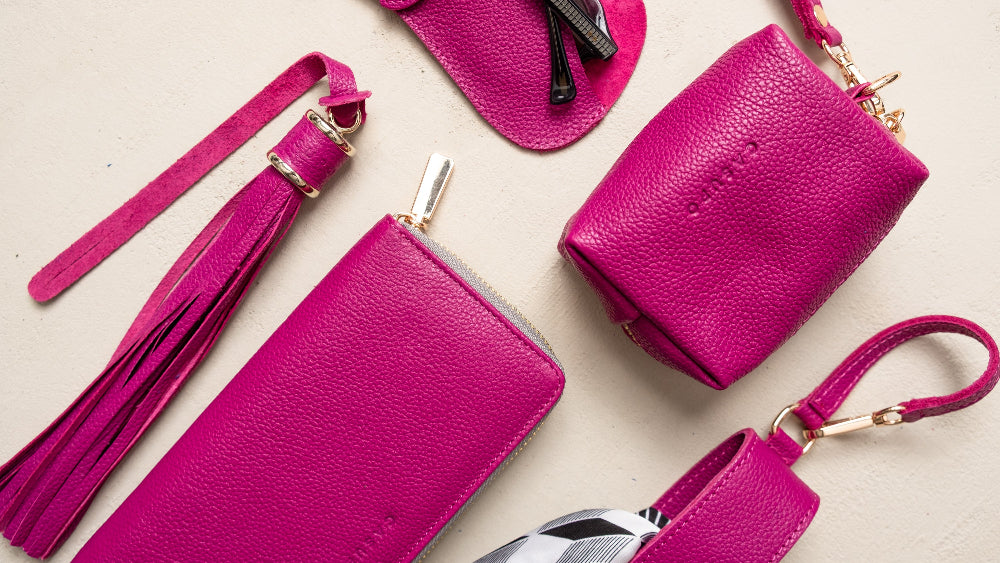 Set of pink leather bags and accessories on a light beige background