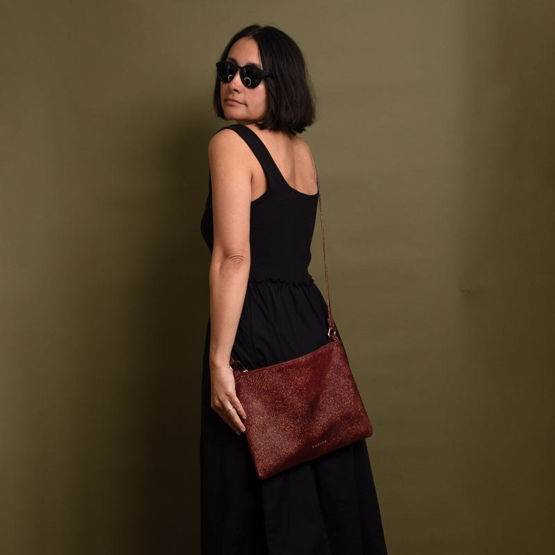 Woman wearing a rose gold leather crossbody bag