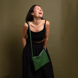Happy woman wearing green leather crossbody bag