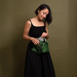 woman holding green leather clutch