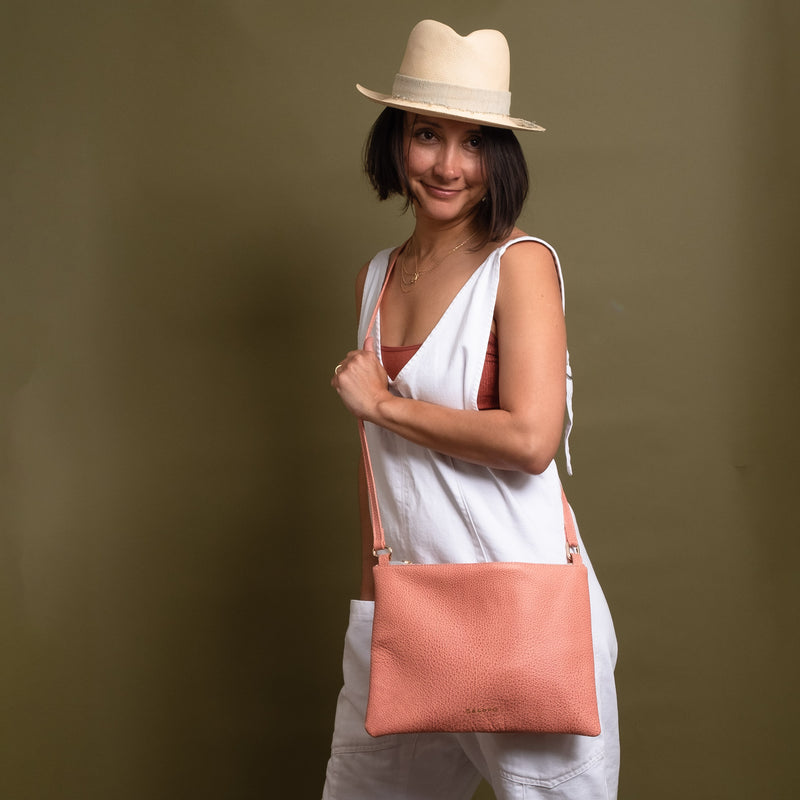Happy woman wearing pink leather crossbody bag