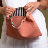 Pink leather clutch with white and blue cotton lining