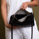 Black crossbody bag with white and blue striped cotton lining