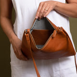 Brown leather crossbody bag with white and navy striped cotton lining