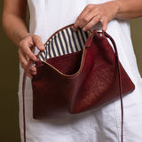 Burgundy sparkle leather crossbody bag for women with striped white and blue cotton lining.