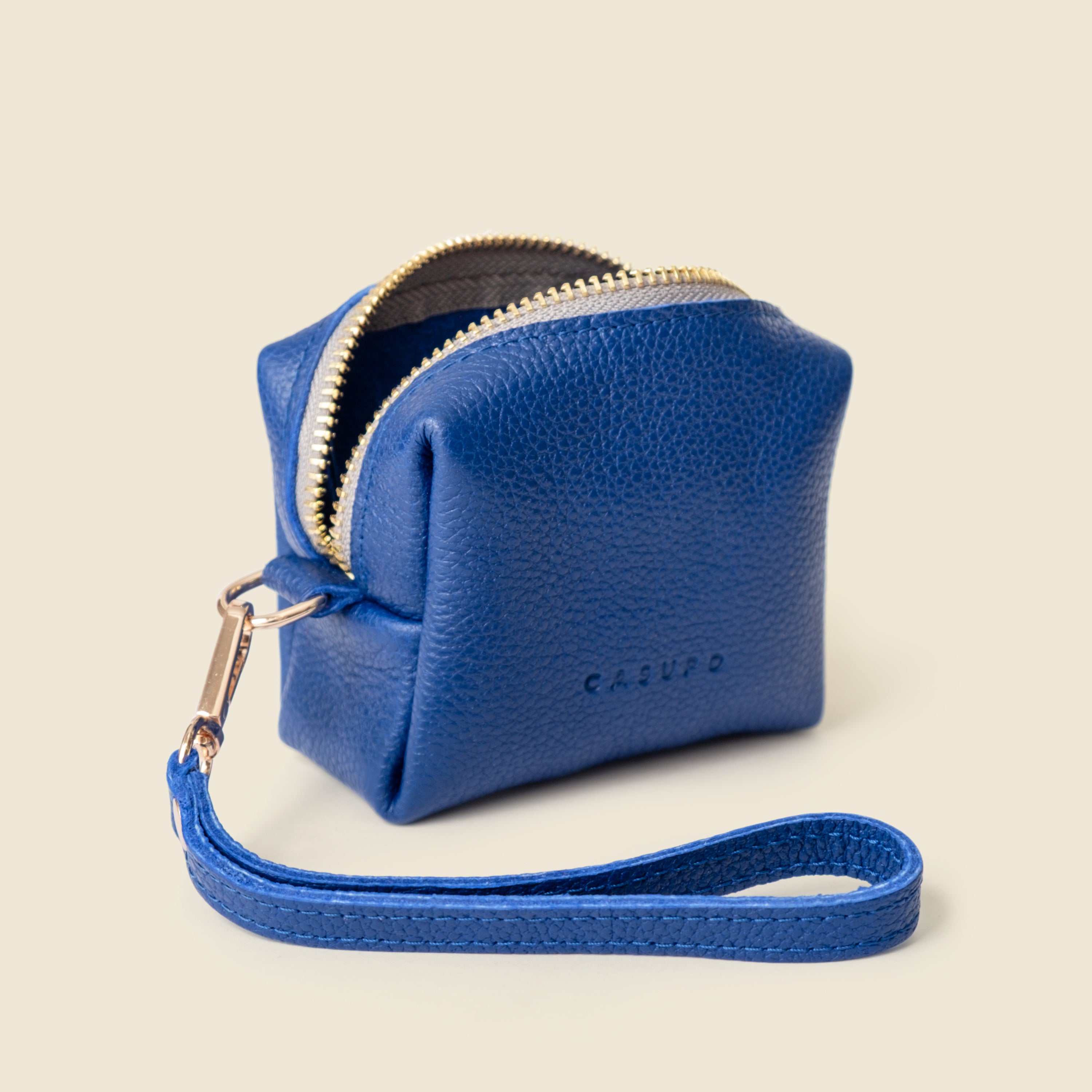 Blue leather purse with a strap on a beige background
