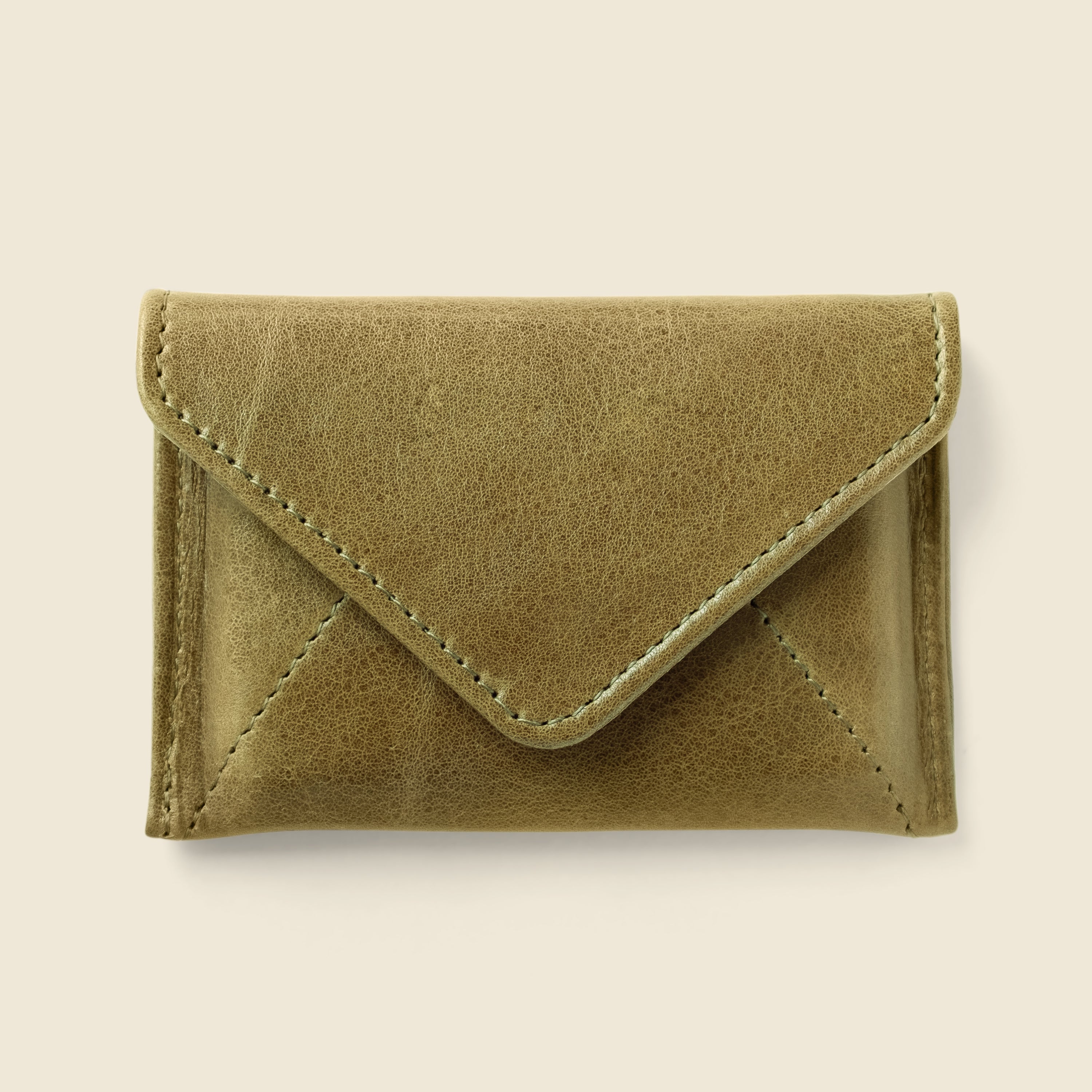 Green suede wallet on a beige background