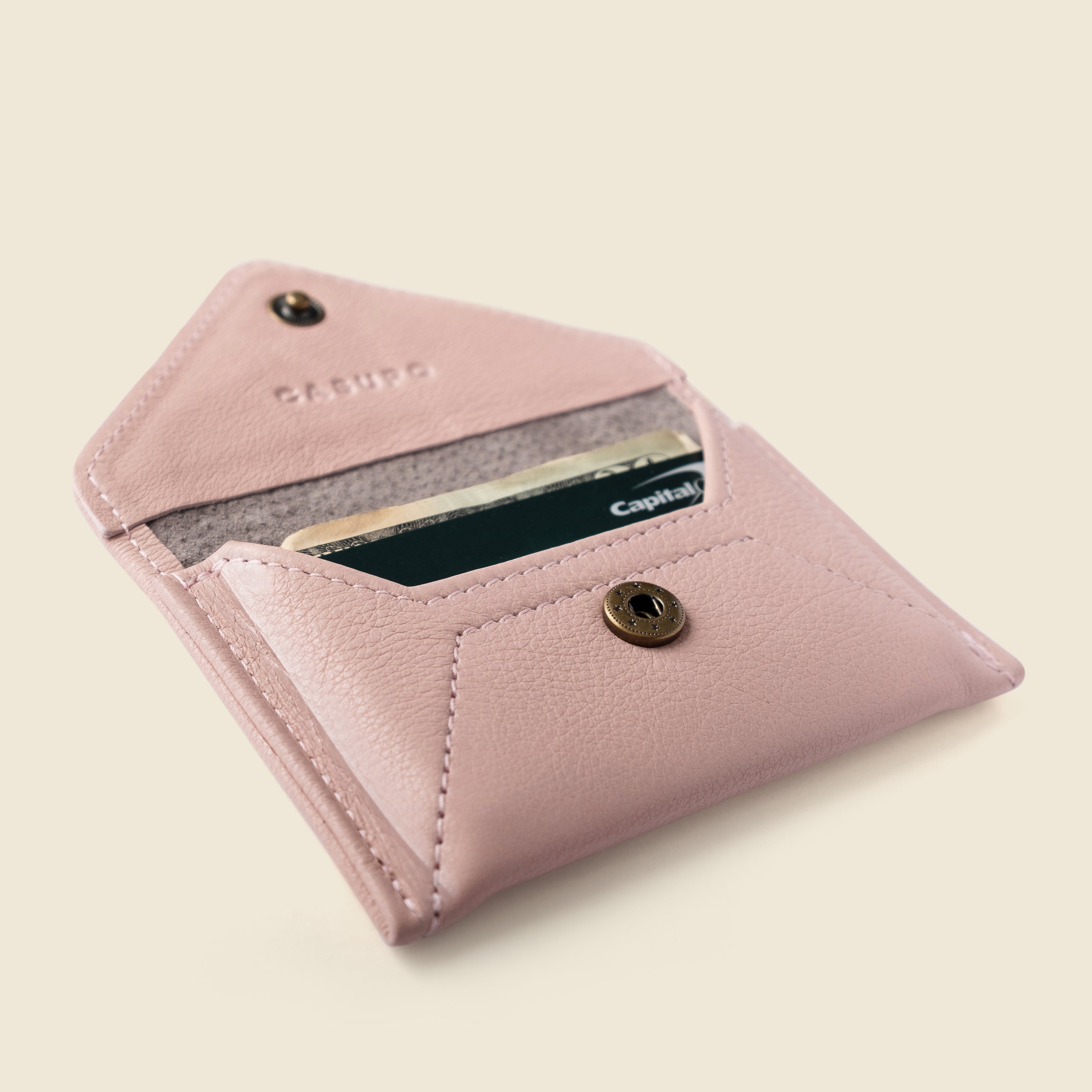 Pink wallet with a card slot on a beige background