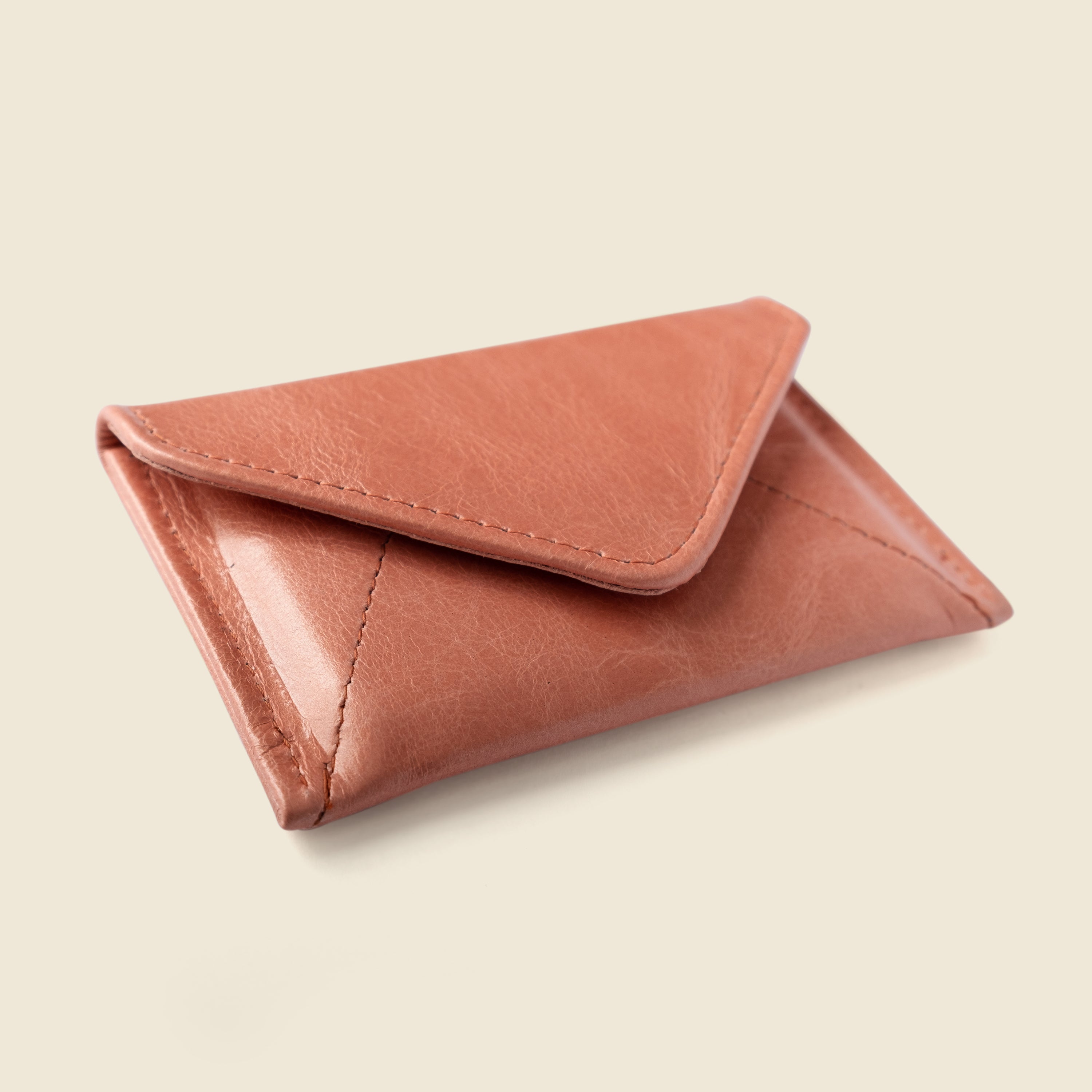 Pink leather cardholder on a beige background