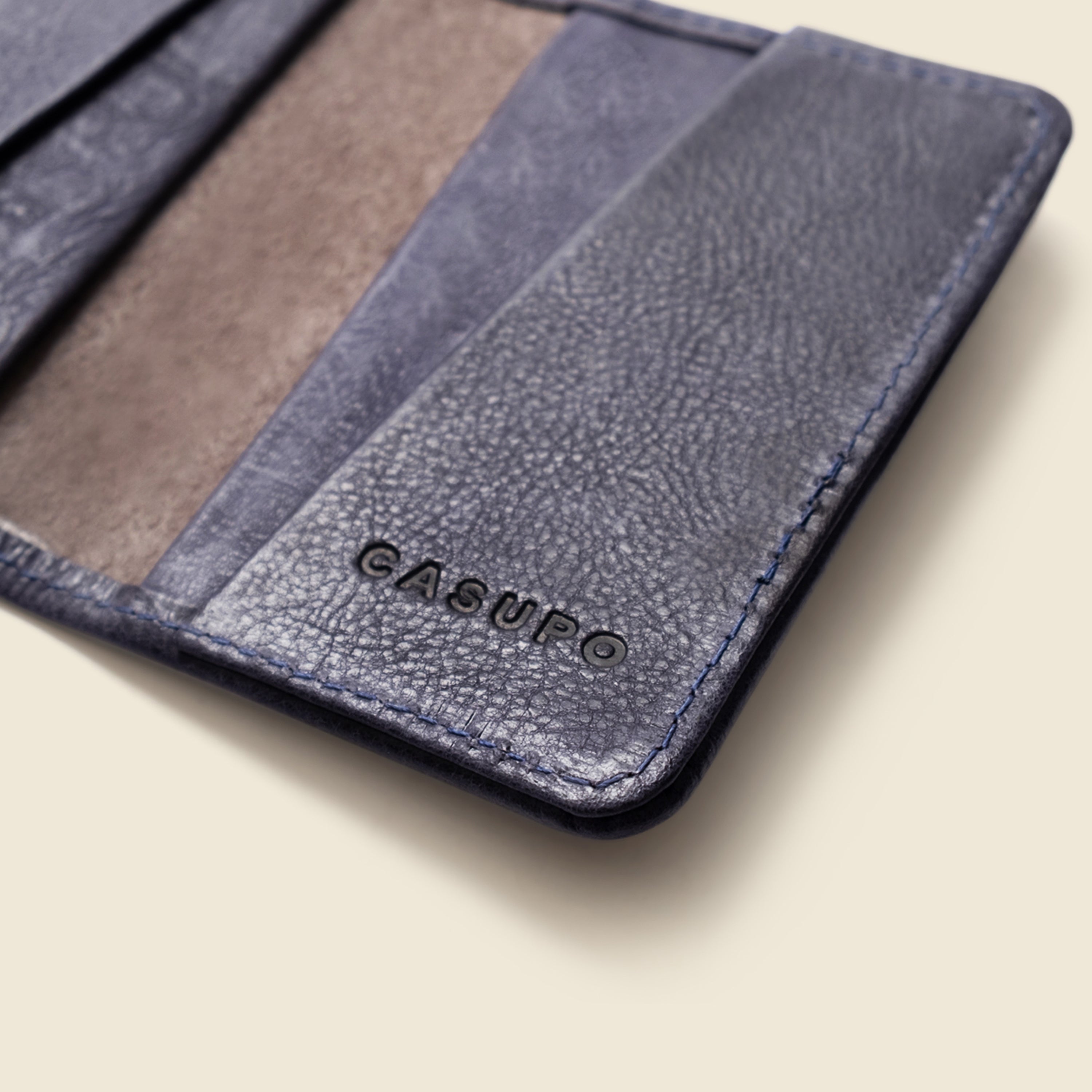 Blue leather wallet with 'Cadorobo' branding on a white background