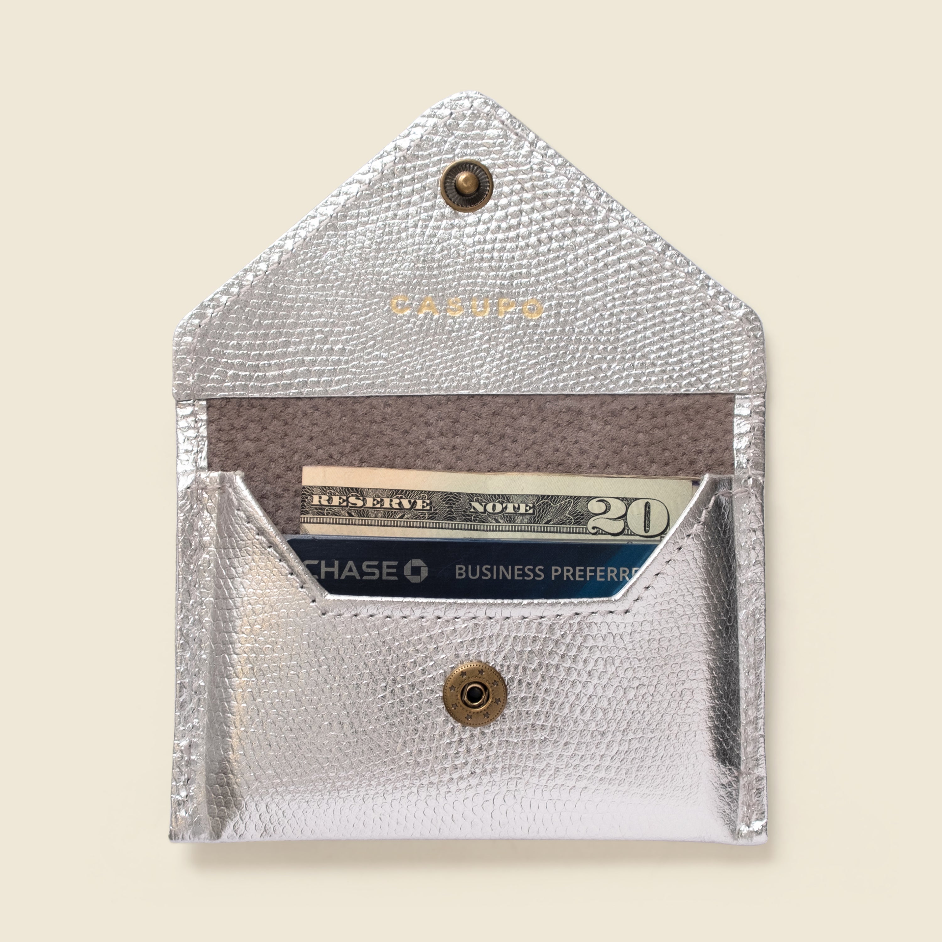 Silver cardholder with a card inside on a beige background