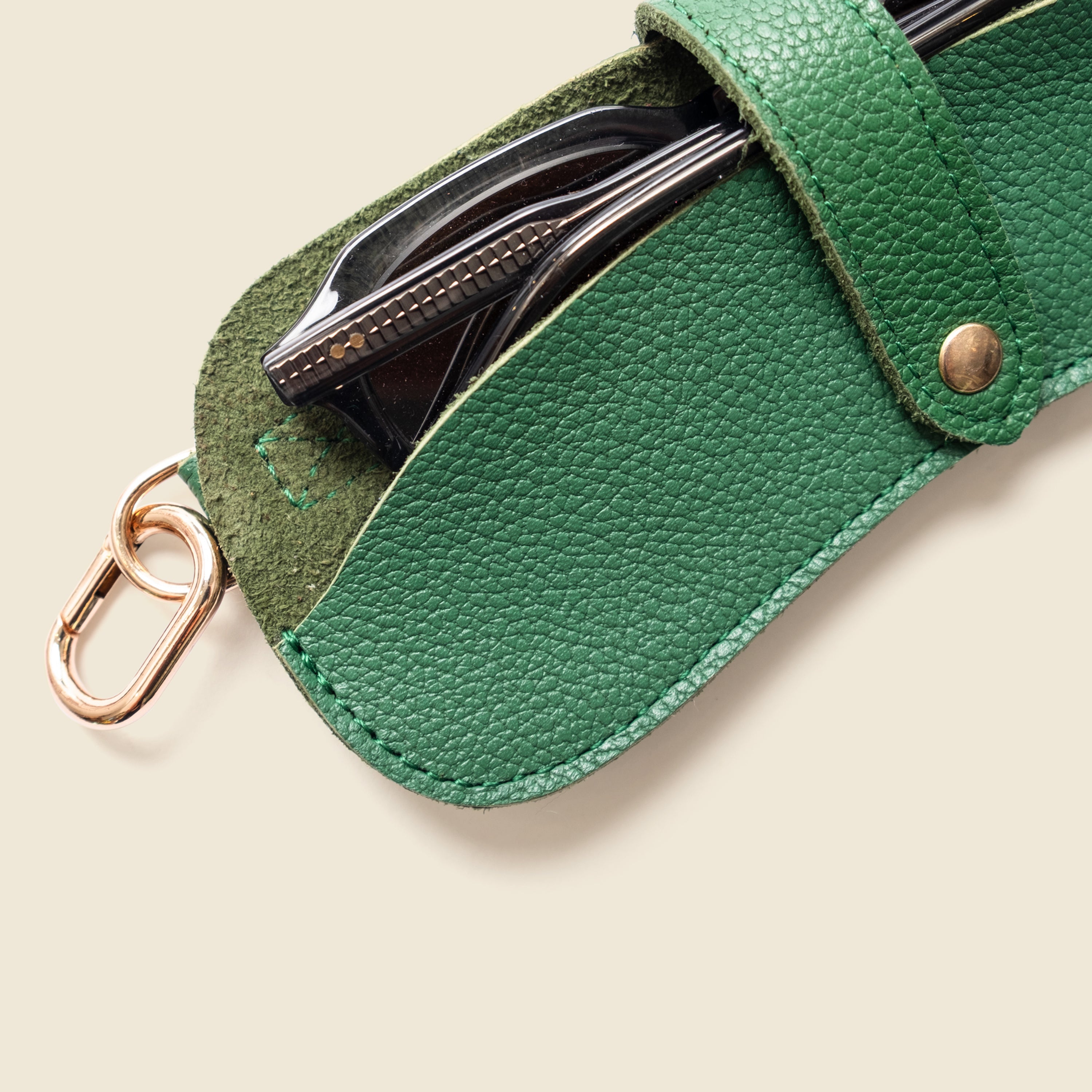 Green leather keychain with a carabiner on a white background