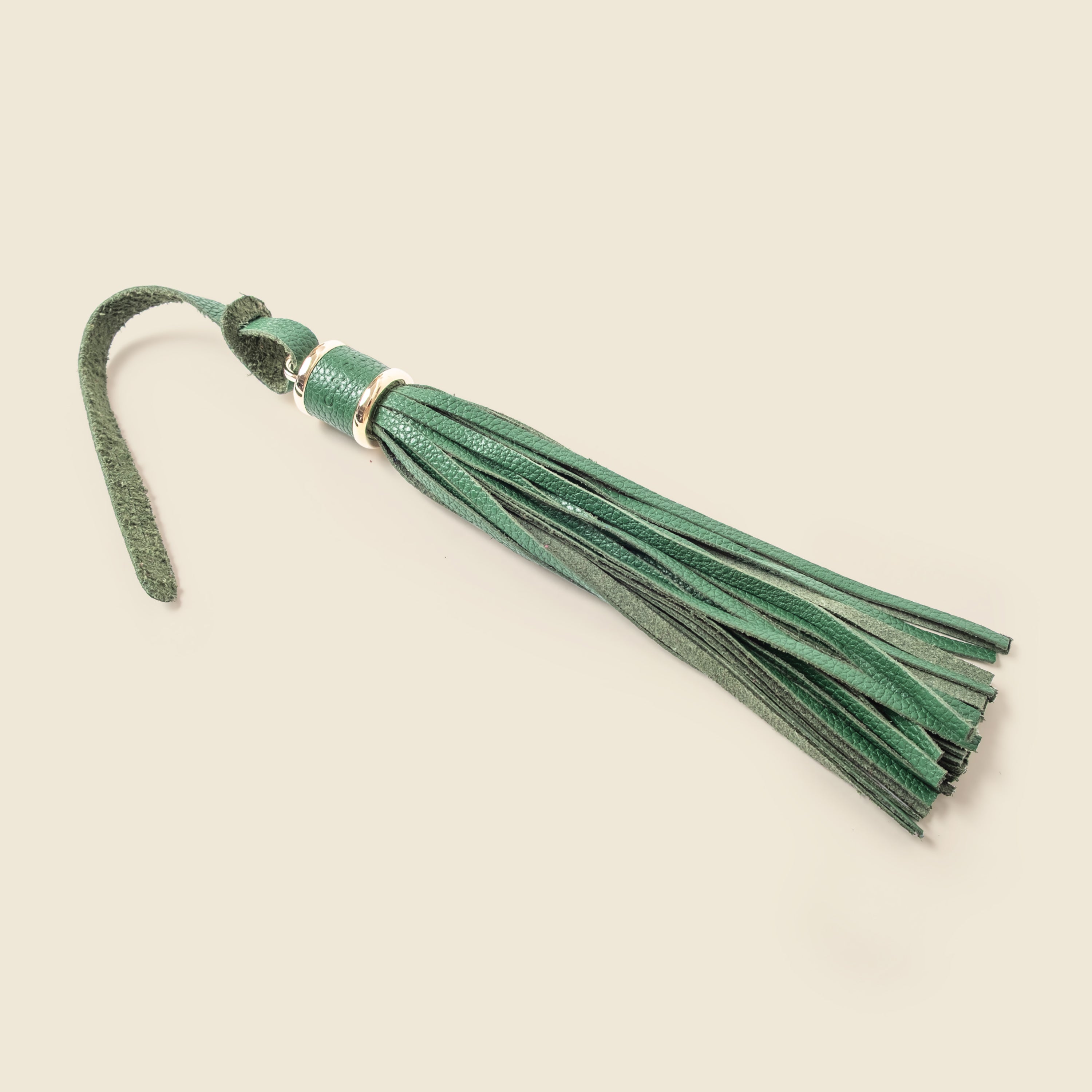Green suede tassel on a beige background