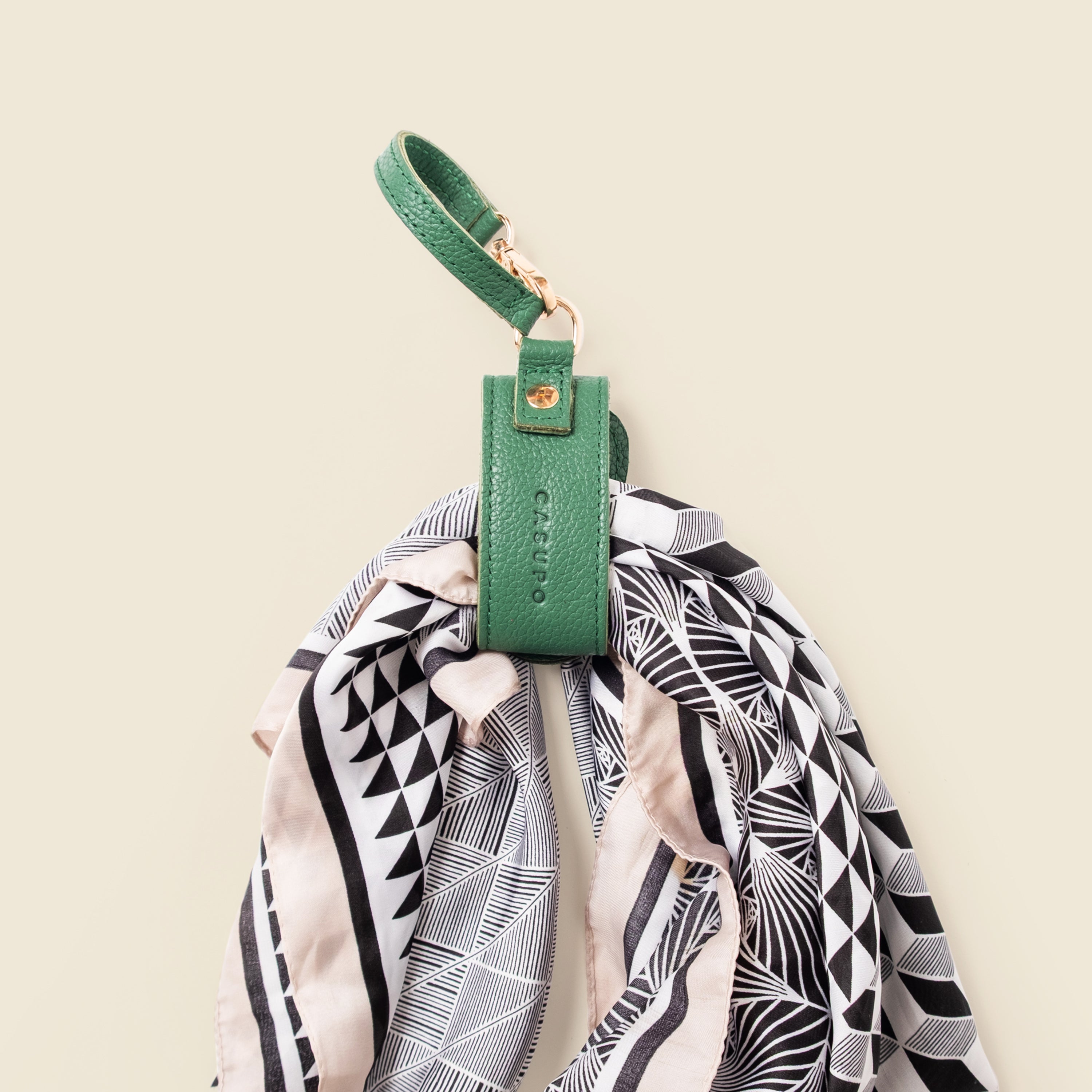Green keychain with a patterned scarf on a beige background