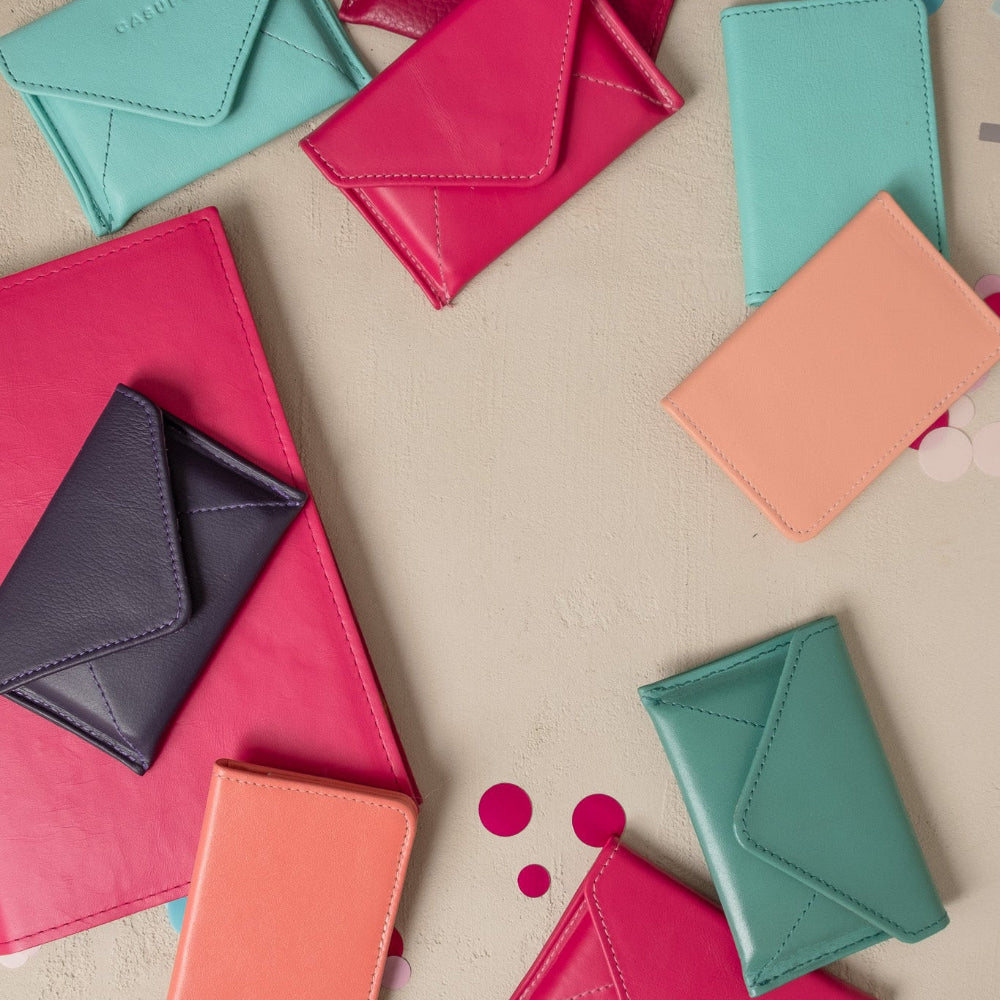 Colorful leather wallets on a beige surface