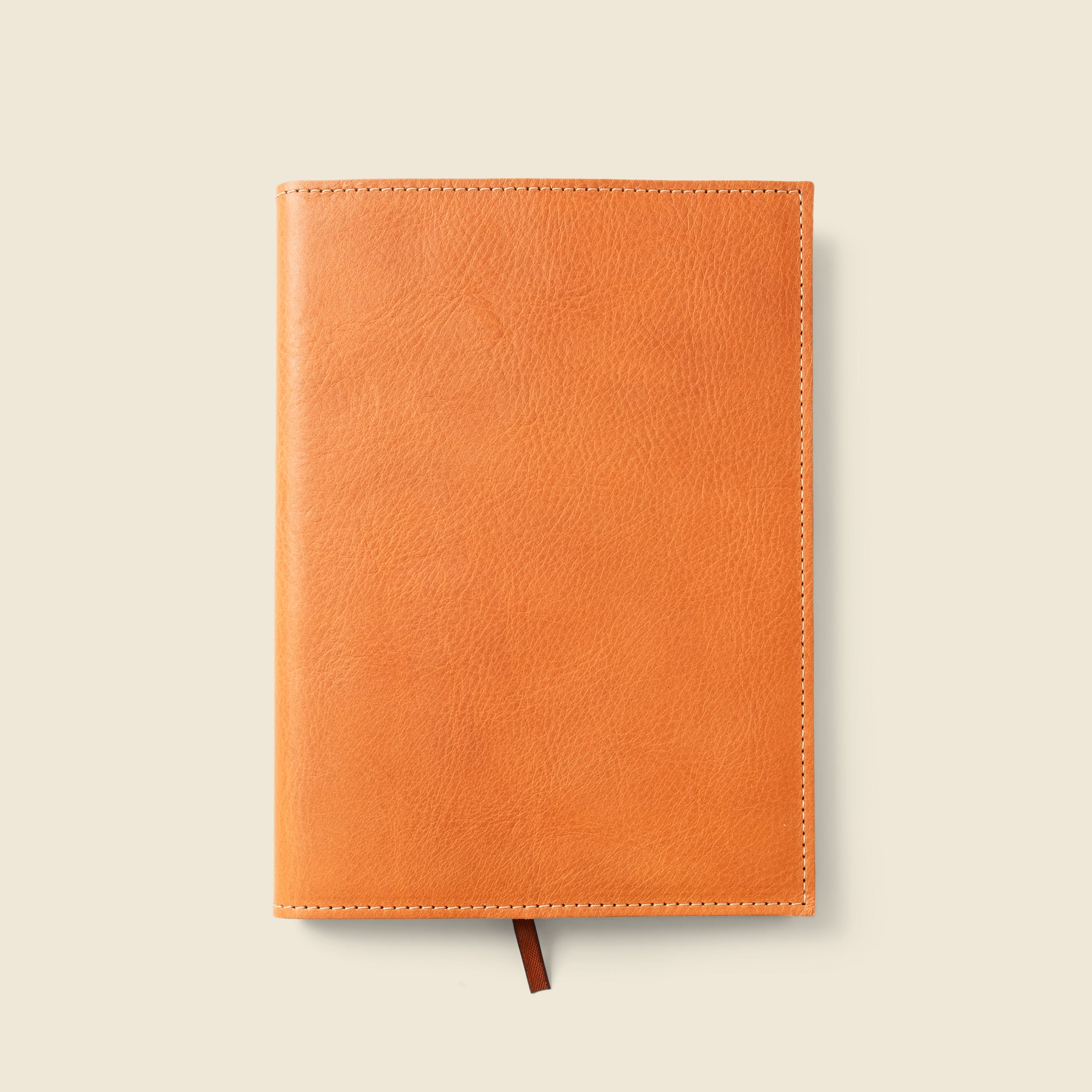 Orange leather notebook on a beige background