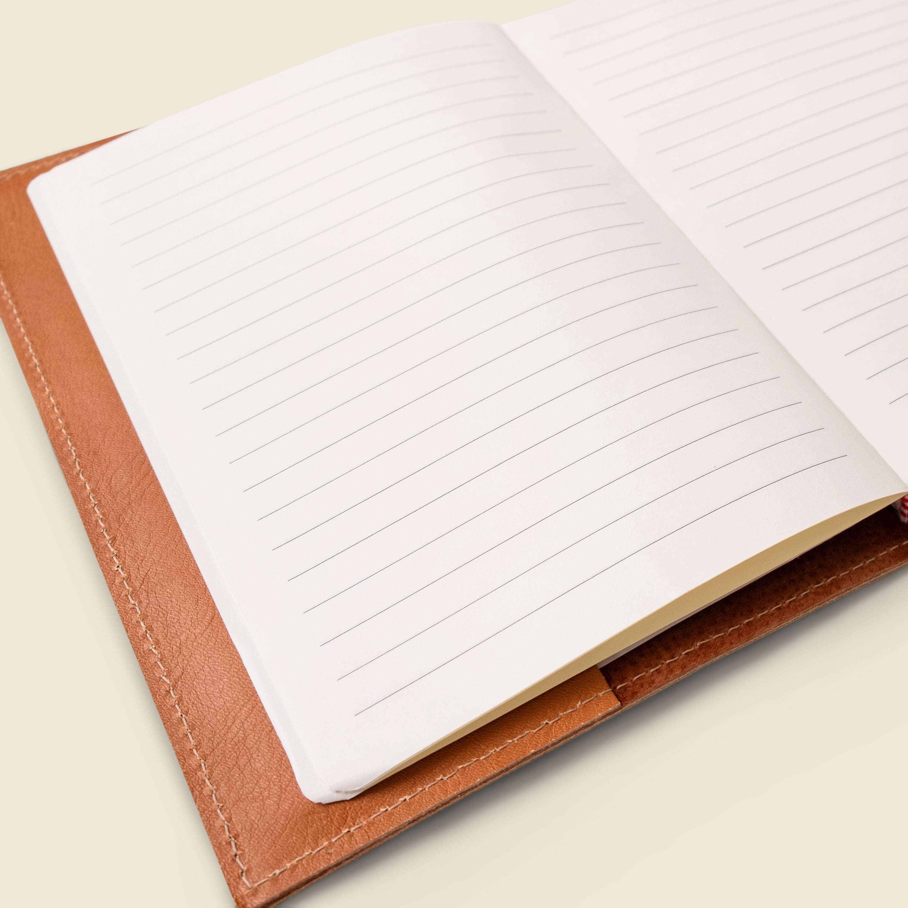 Open notebook with lined pages on a beige background