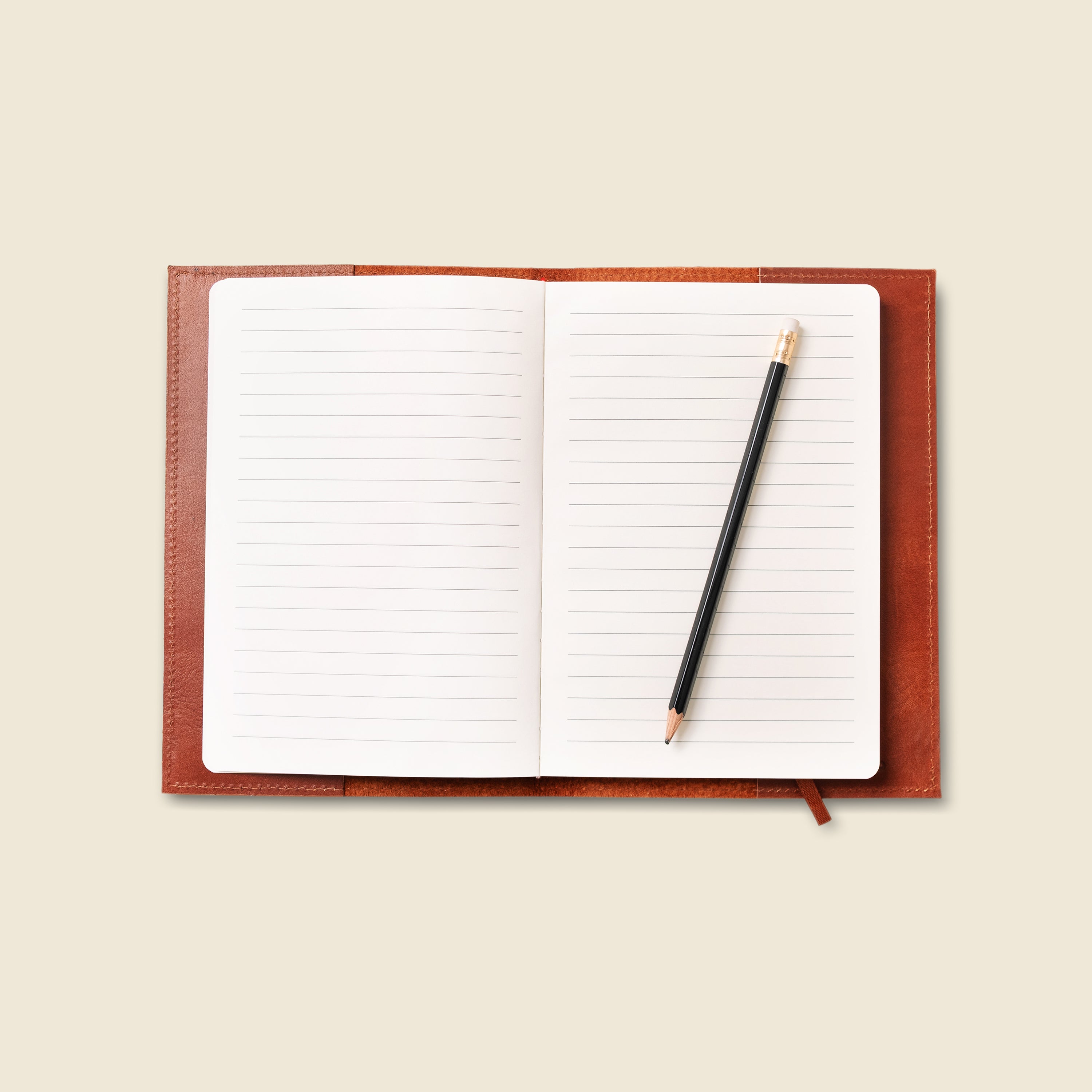 Open notebook with a pen on a beige background