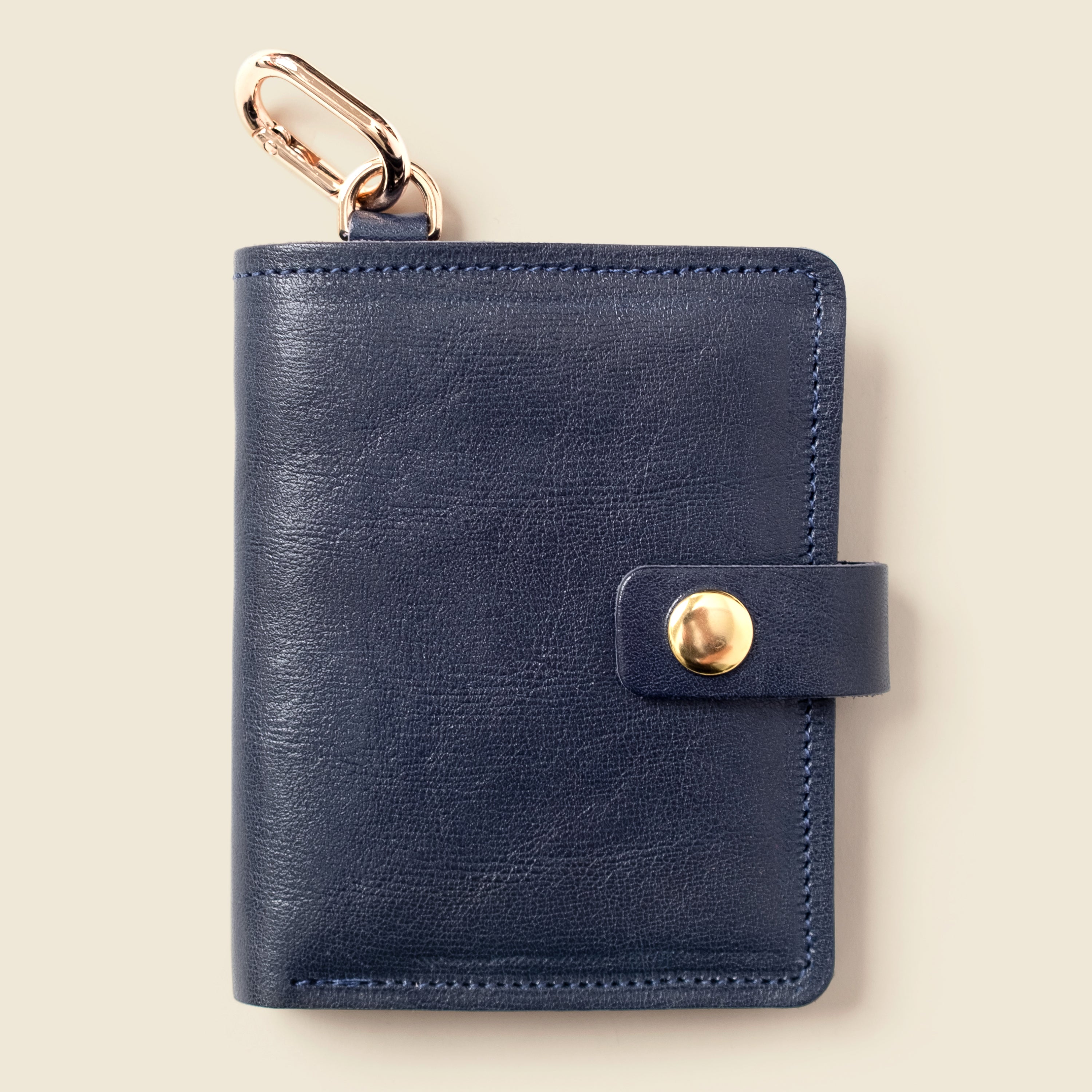 Marine blue leather snap wallet with key ring on beige background — CASUPO