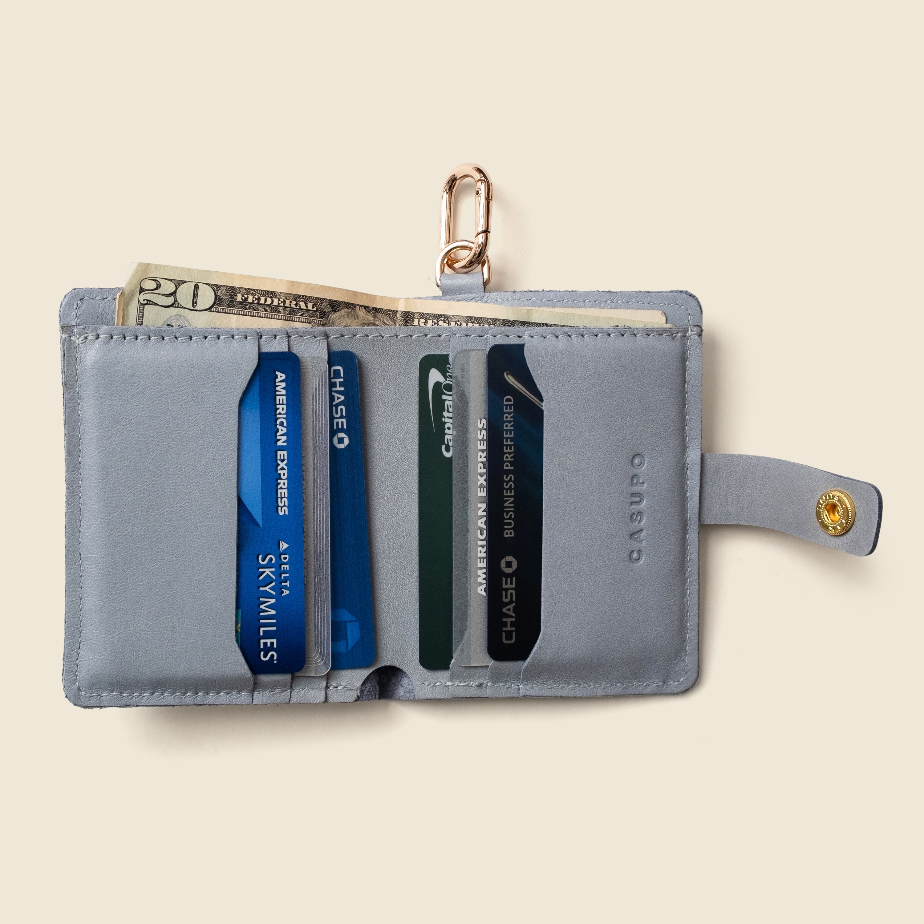 Ice blue leather wallet with key ring, front view on neutral background
