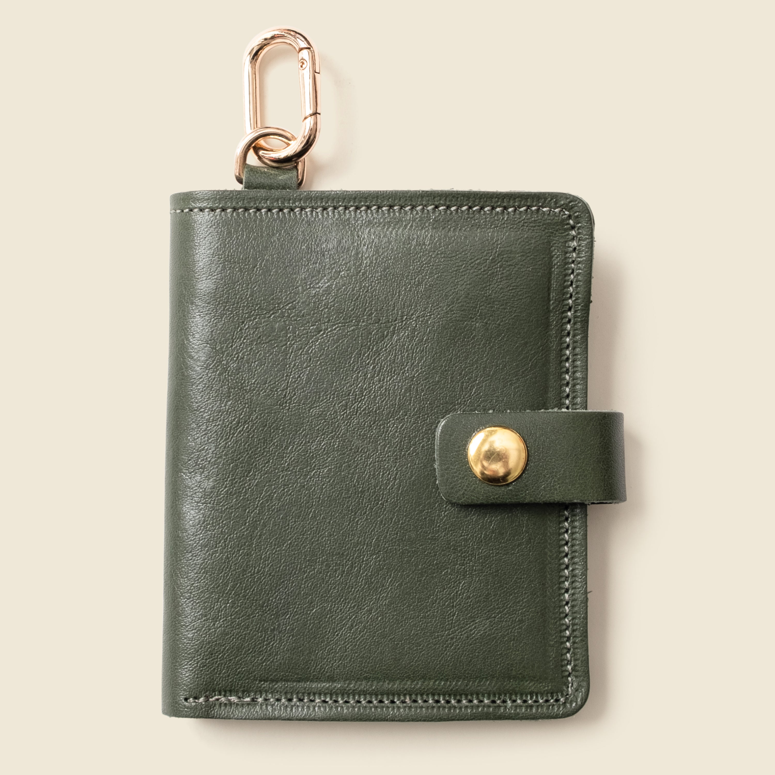 Olive leather snap wallet with key ring on beige background — CASUPO
