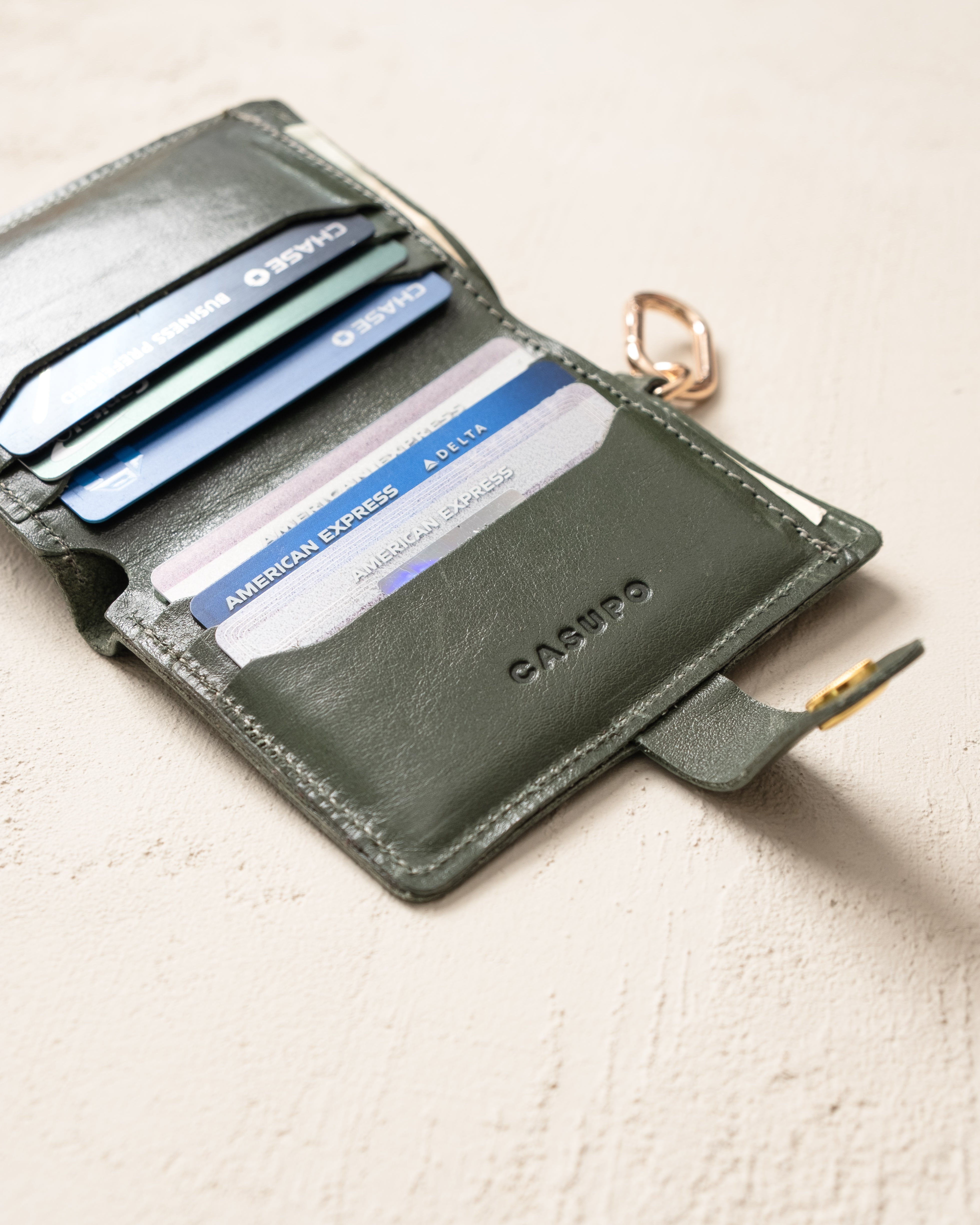 Olive snap wallet with key ring, lifestyle flat lay