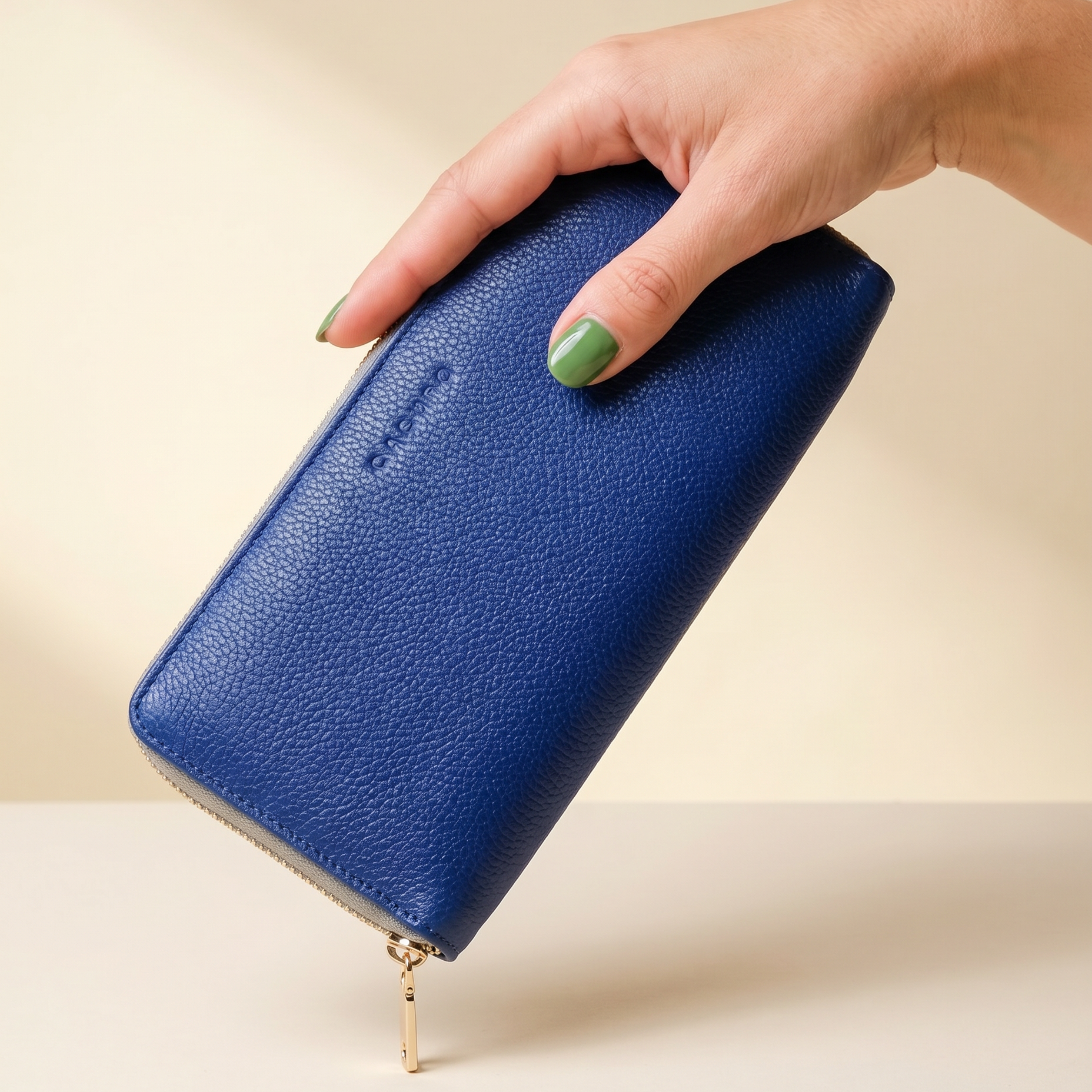 Hand holding a blue wallet against a beige background