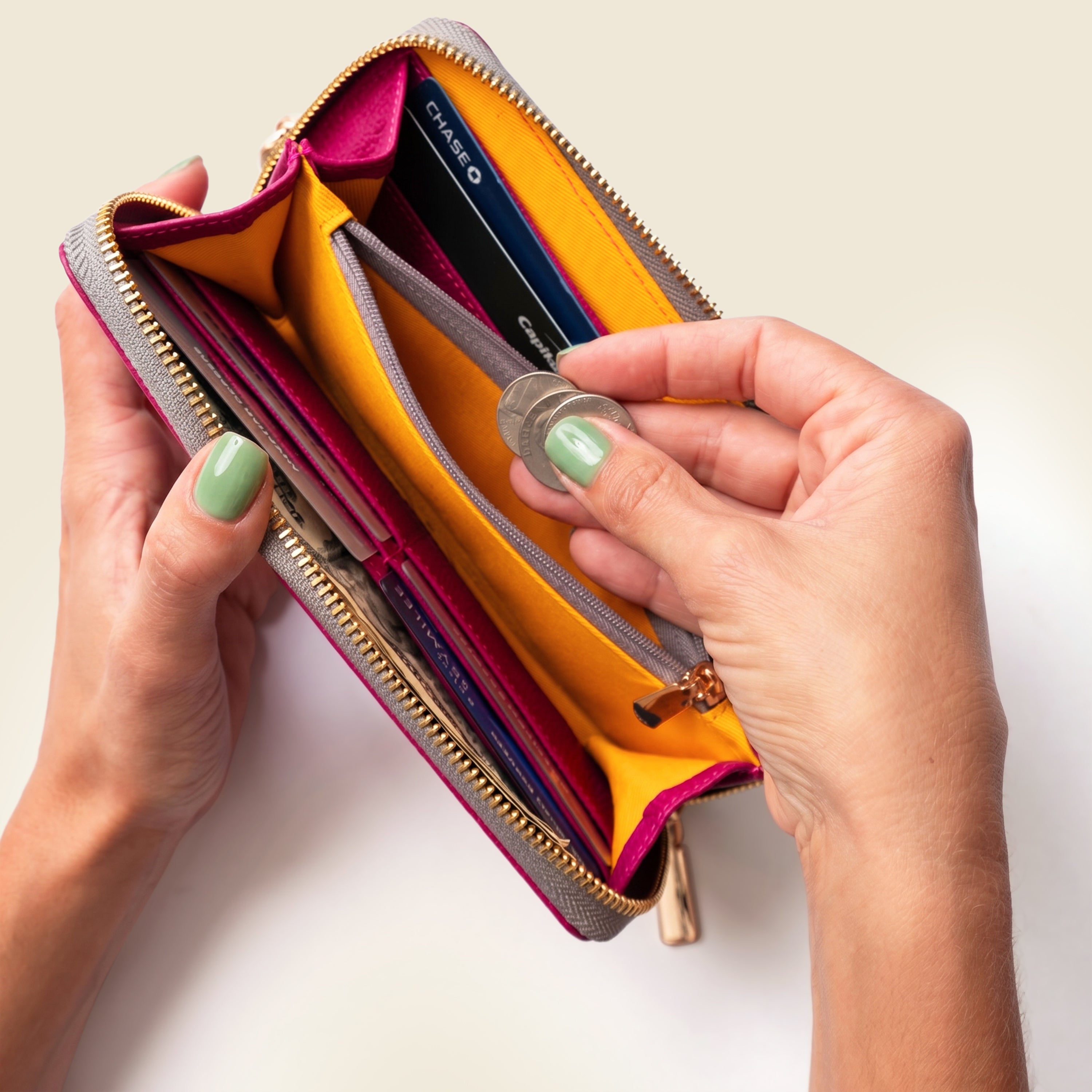 Person holding an open wallet with a coin and cards on a light background